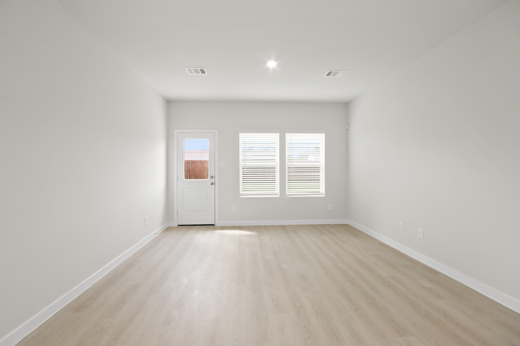 A room with a wood floor and a door with a window.