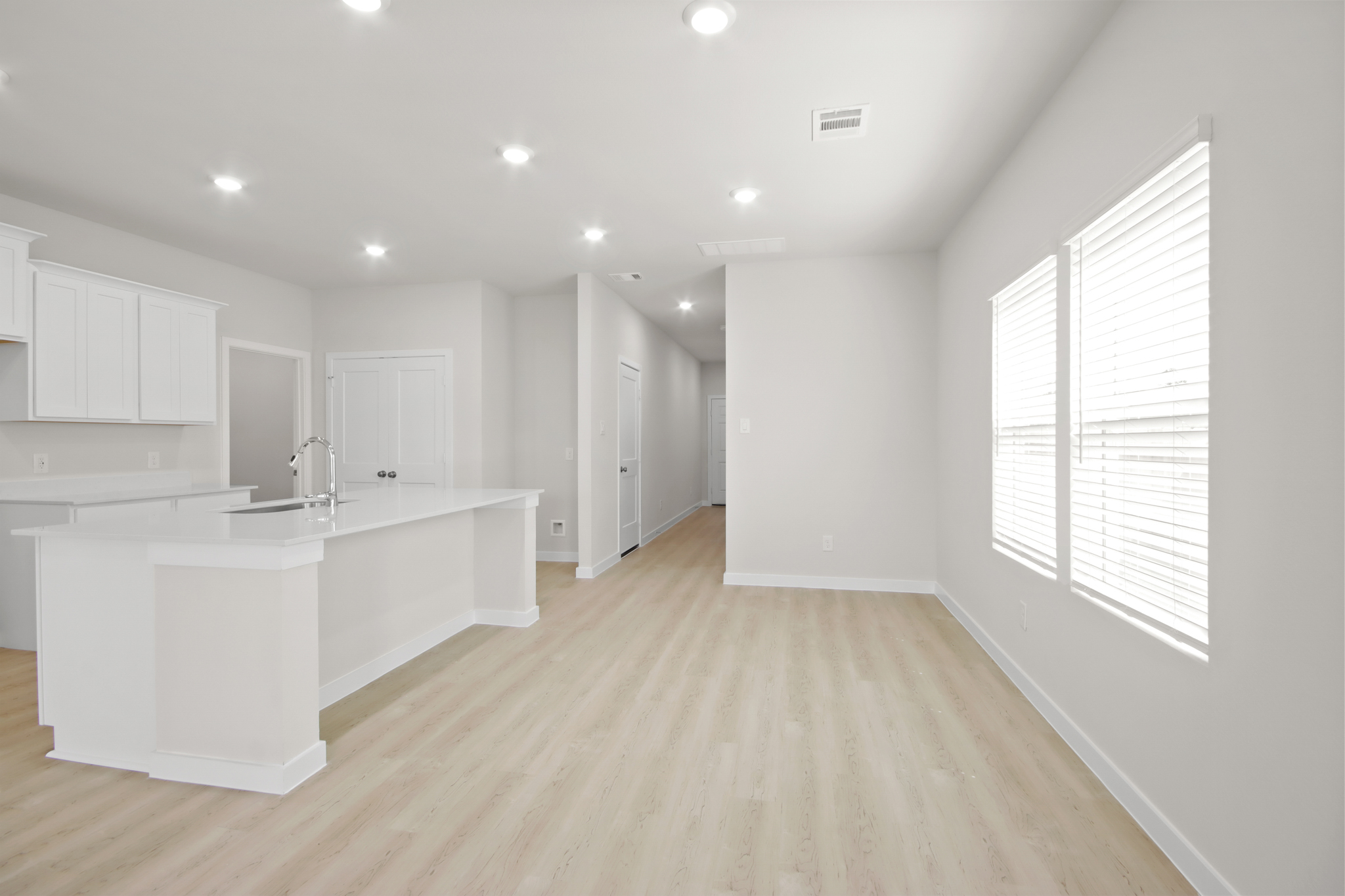 A kitchen with white cabinets.