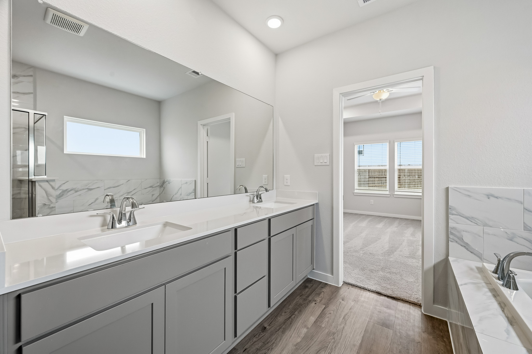 A bathroom with a tub sink and a mirror.