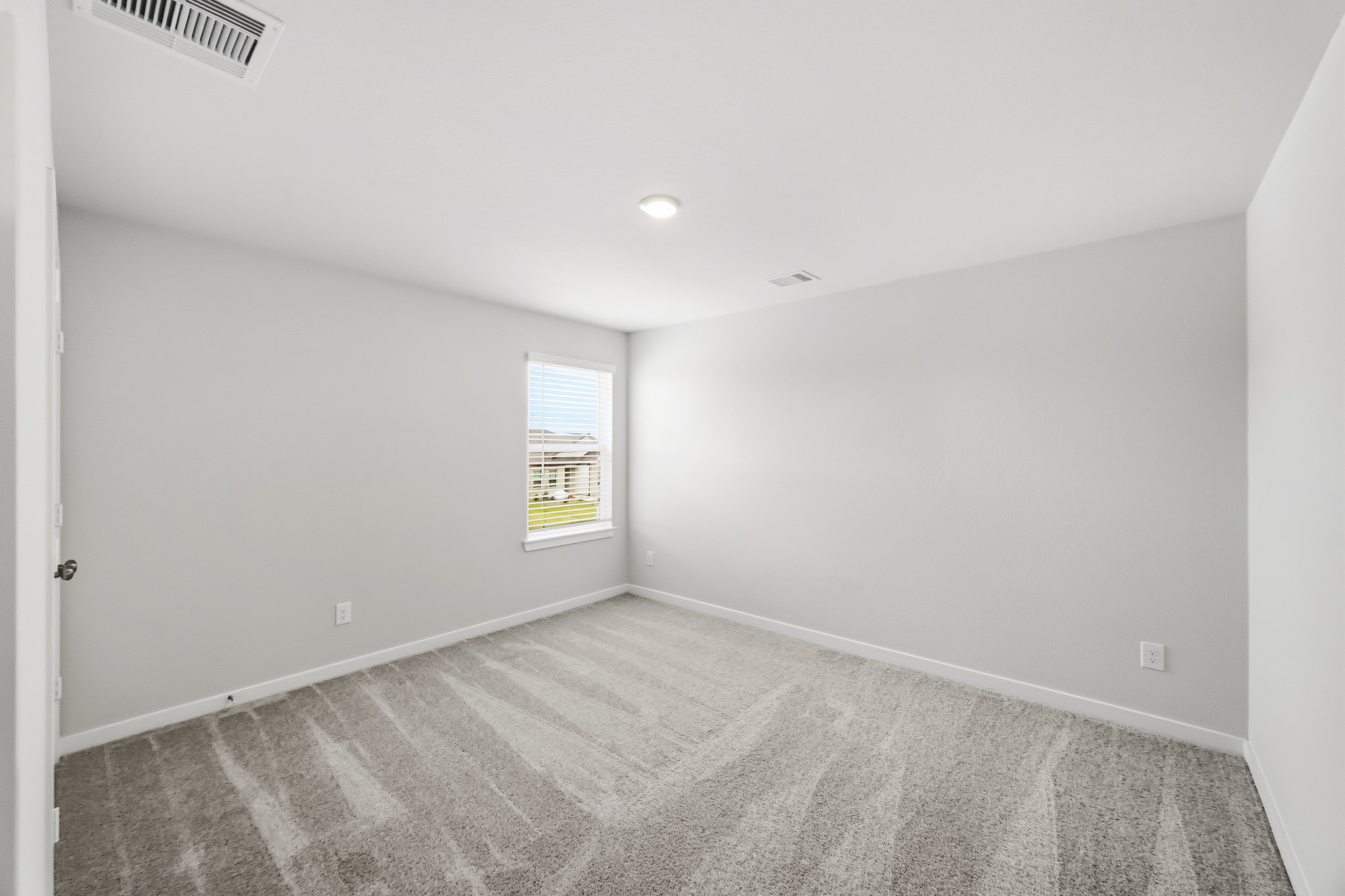 A room with a carpet and a window.
