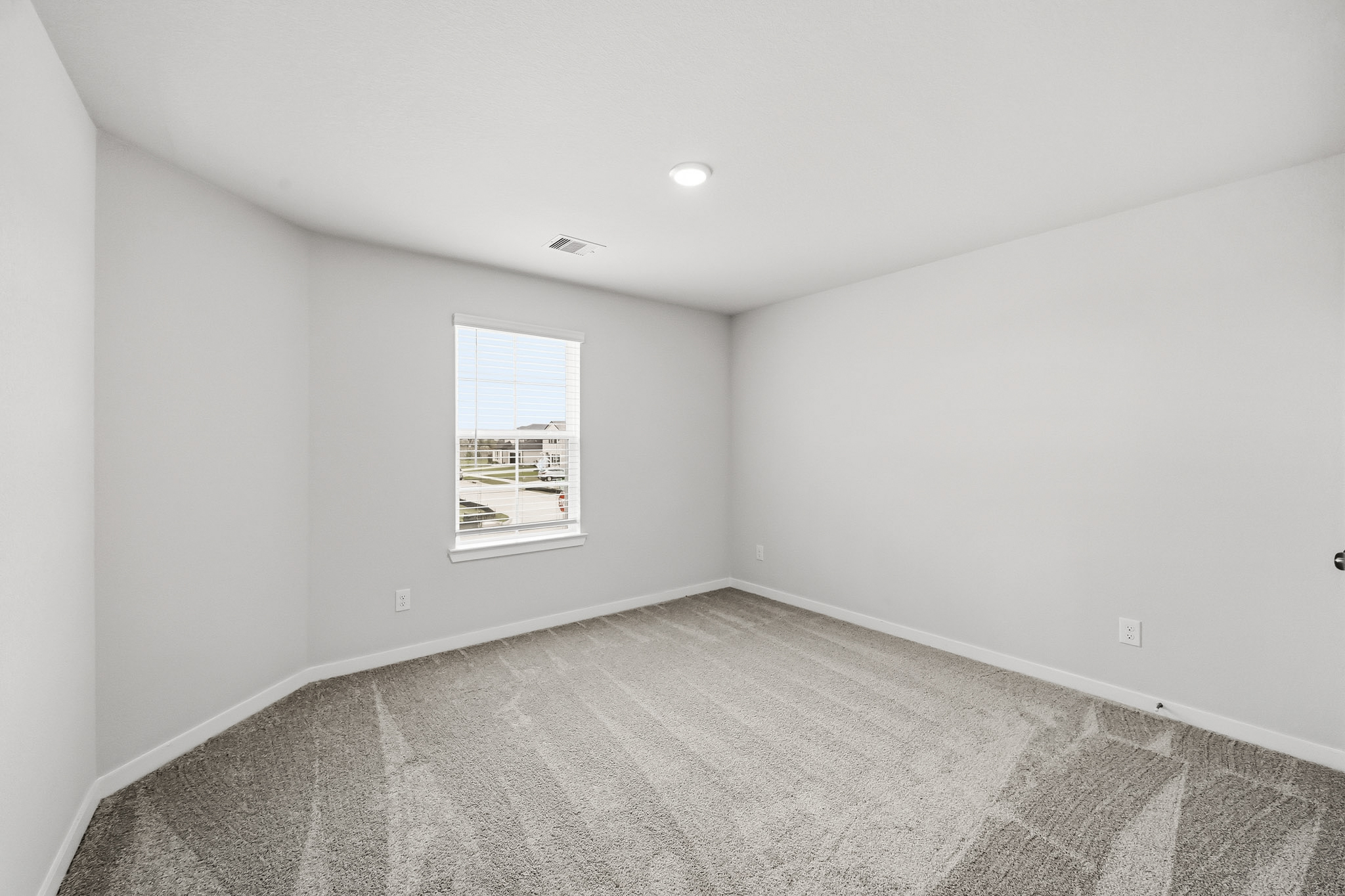 A room with a white wall and a poster on the wall.