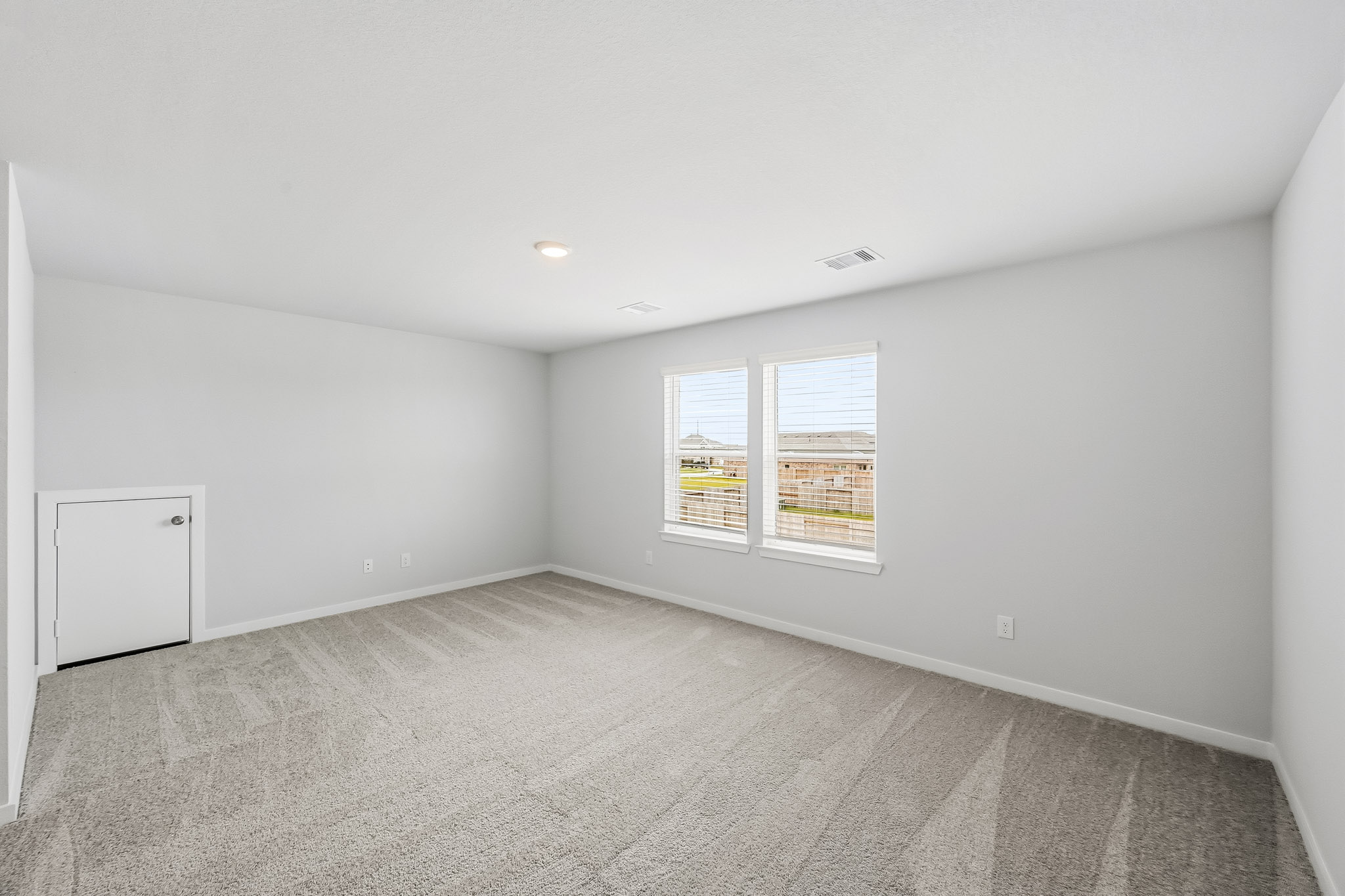 A room with a window and a white wall.