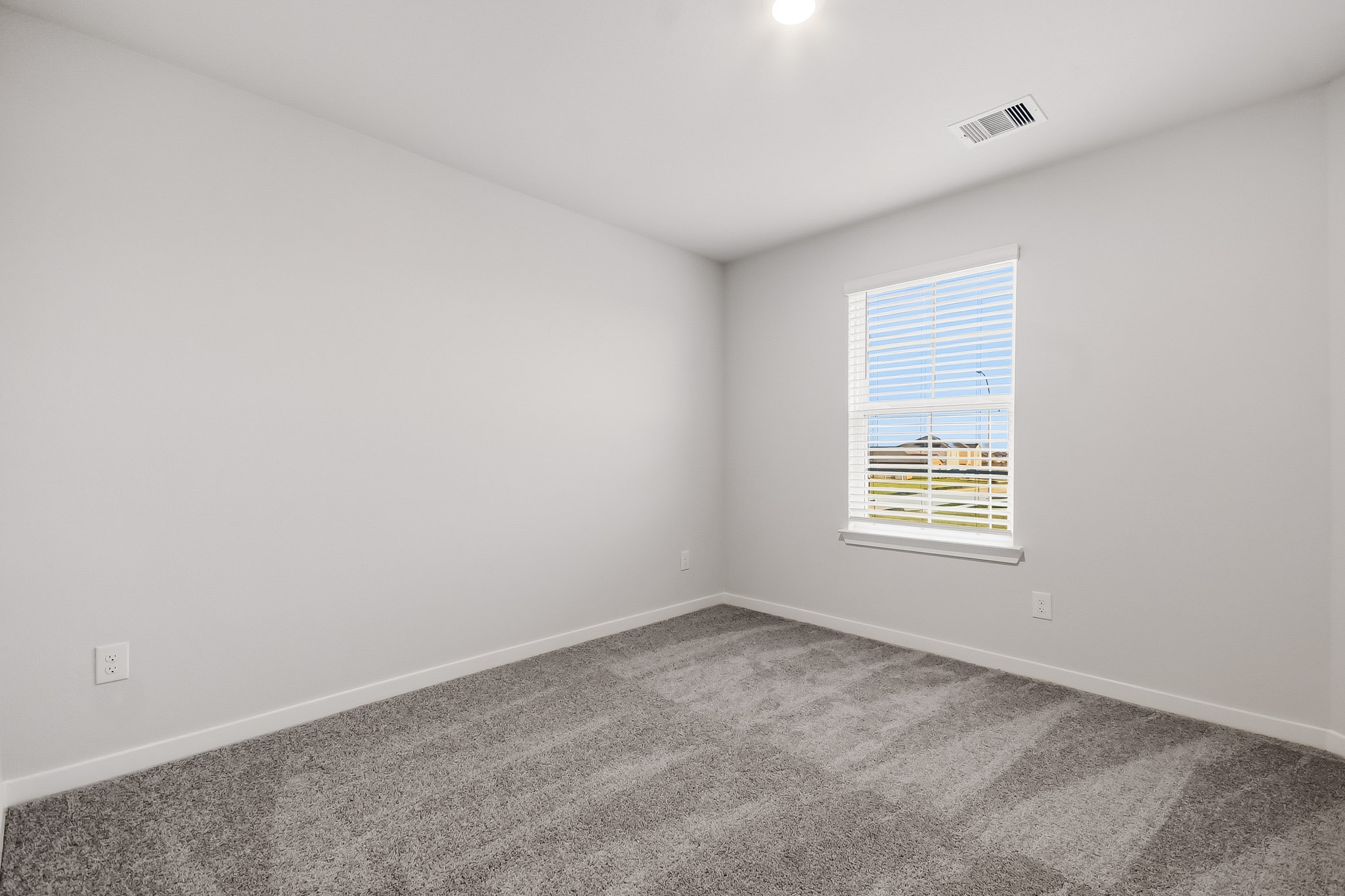 A room with a window and a carpet.