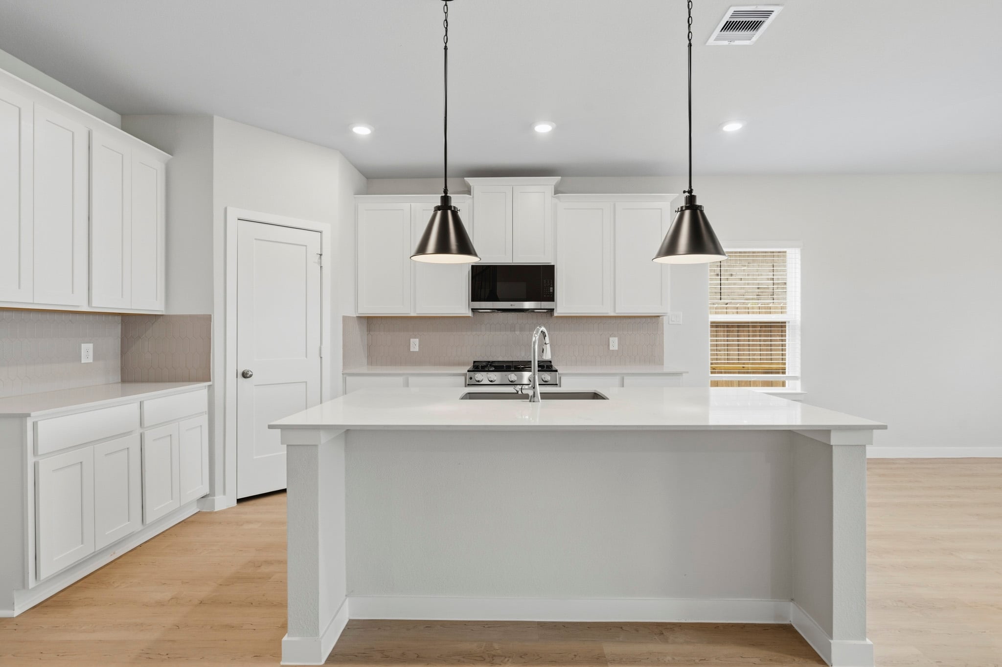 A kitchen with white cabinets.