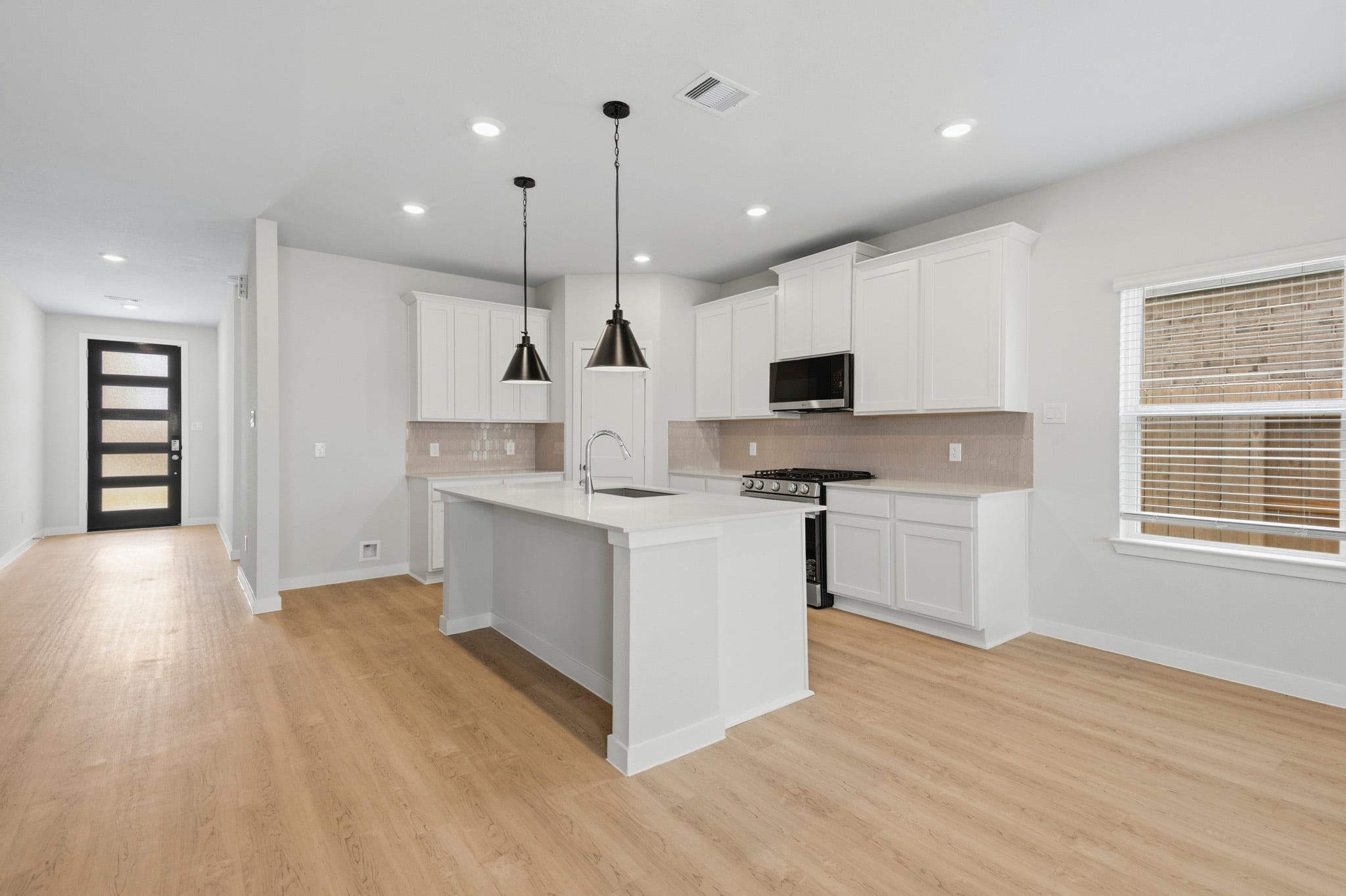 A kitchen with white cabinets.
