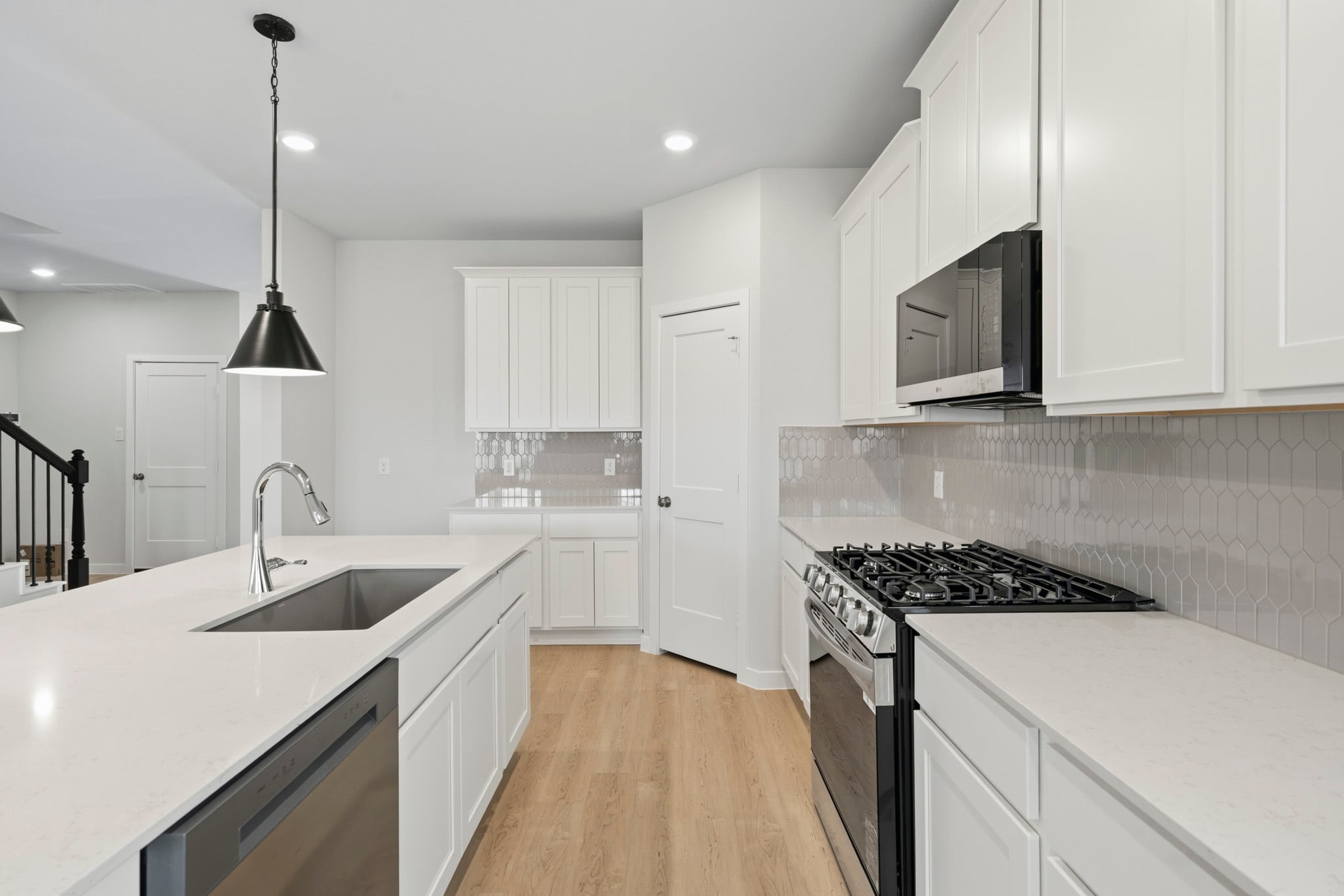 A kitchen with white cabinets.