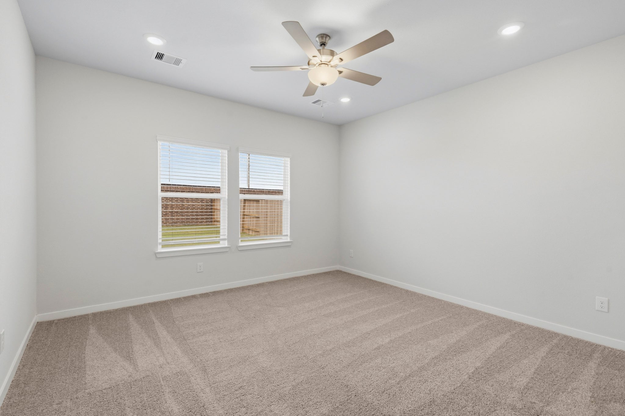A room with a ceiling fan and a window.