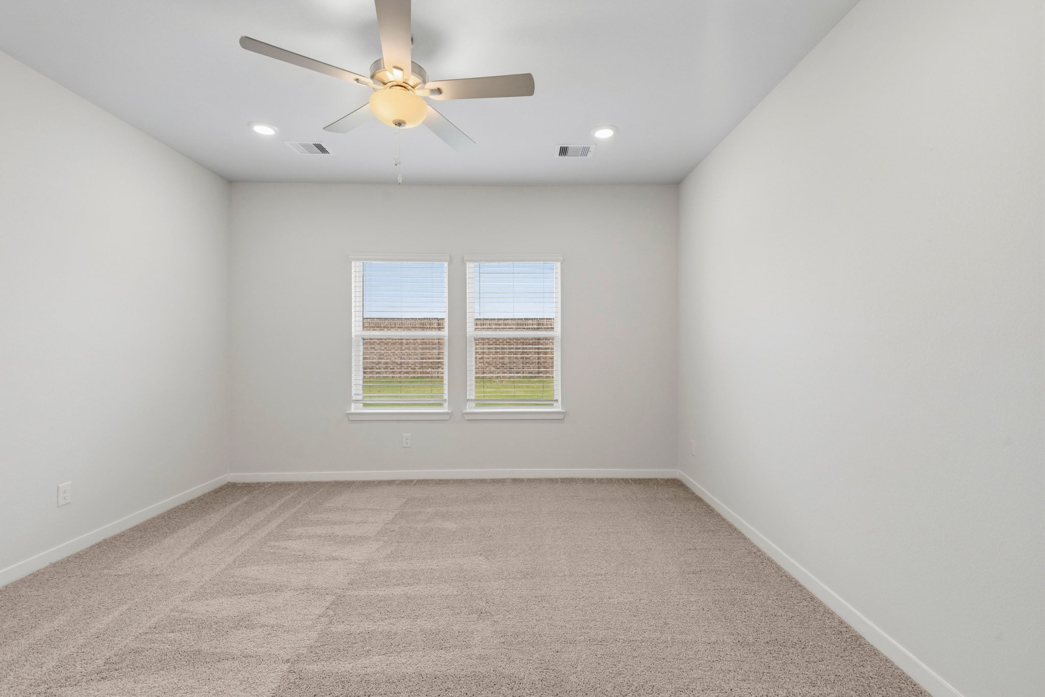 A room with a ceiling fan and a window.