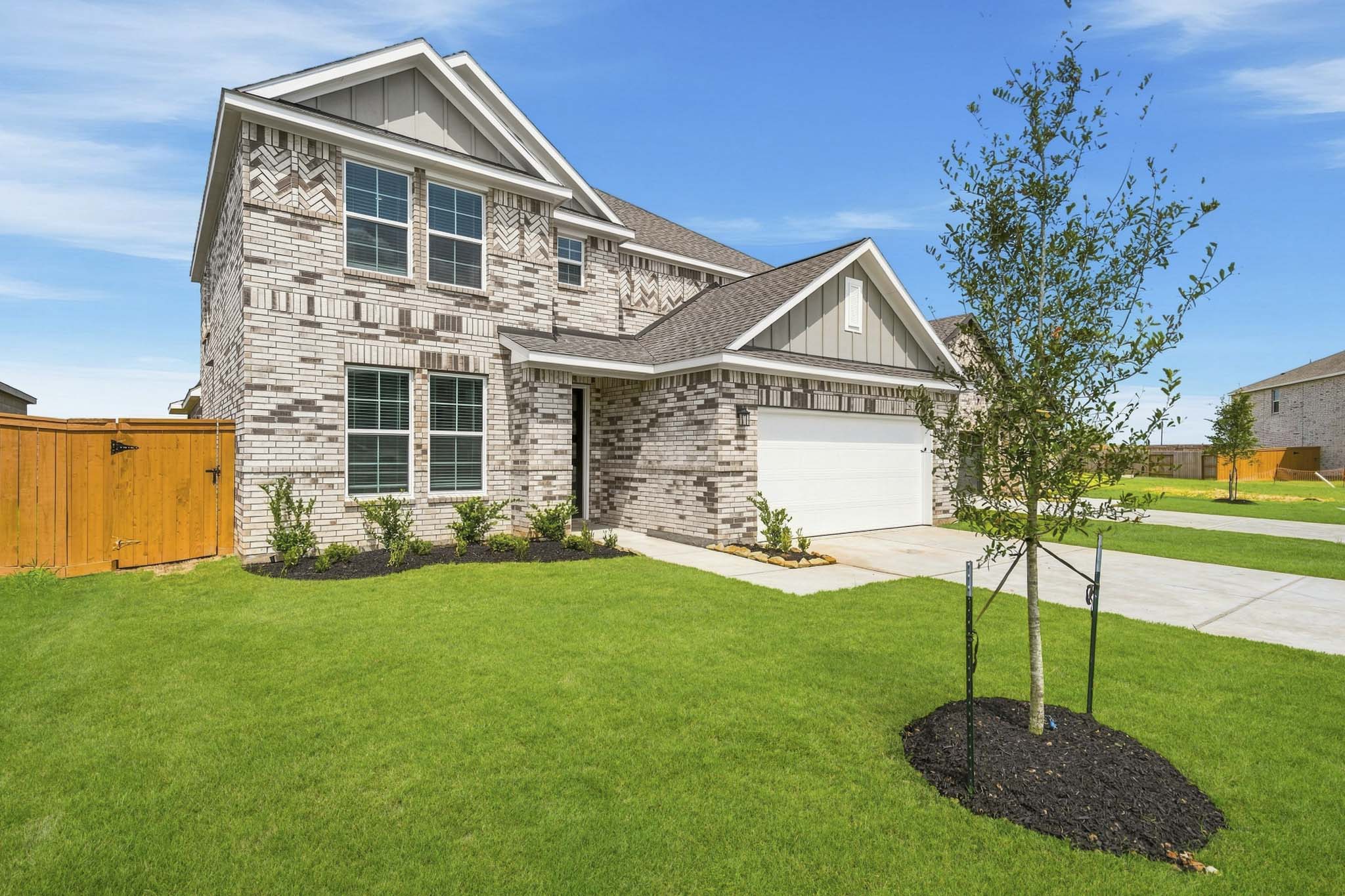 A house with a tree in the front yard.