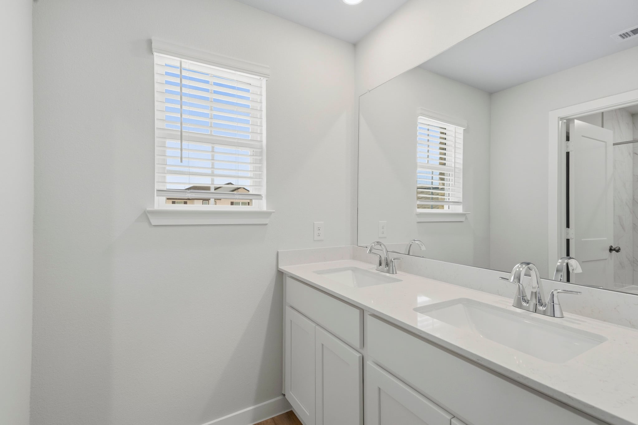 A bathroom with white cabinets.