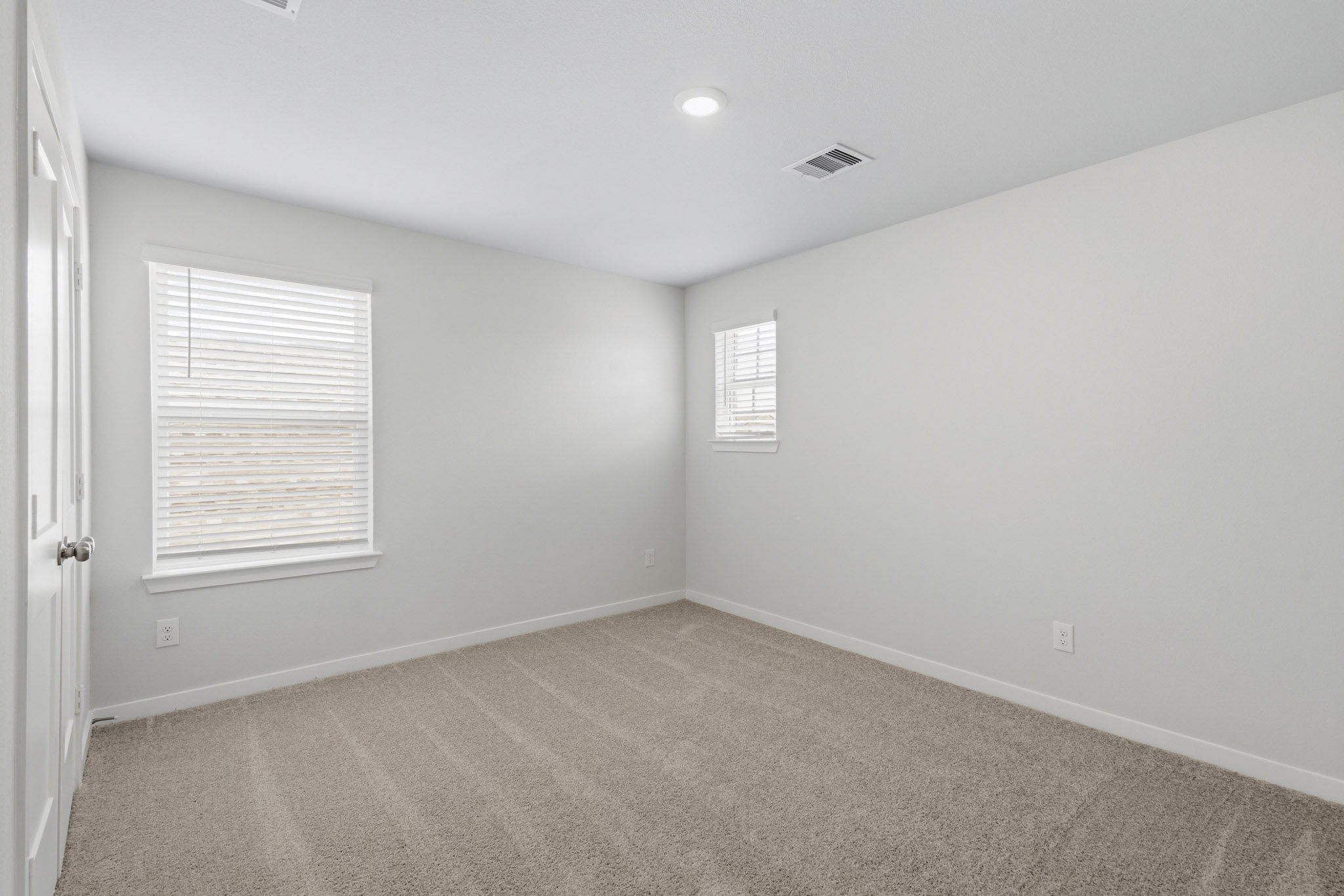 A room with a carpet and a window.