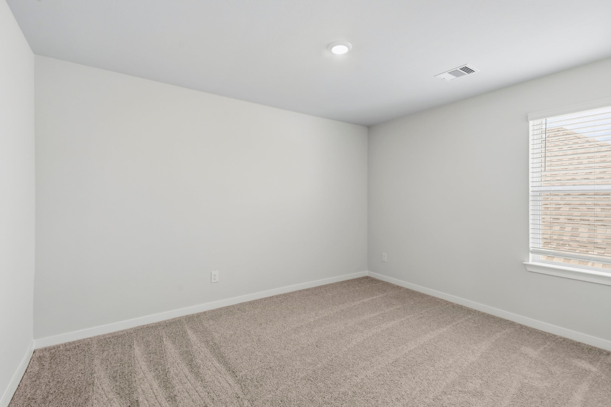 A room with a carpet and a window.
