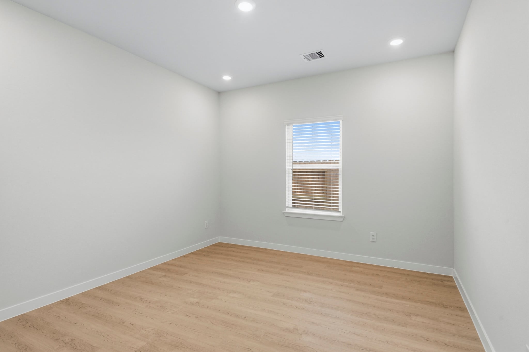 A room with a wood floor and a window.