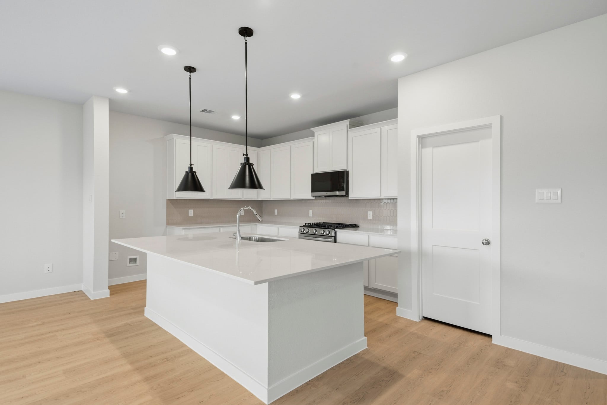 A kitchen with white cabinets.