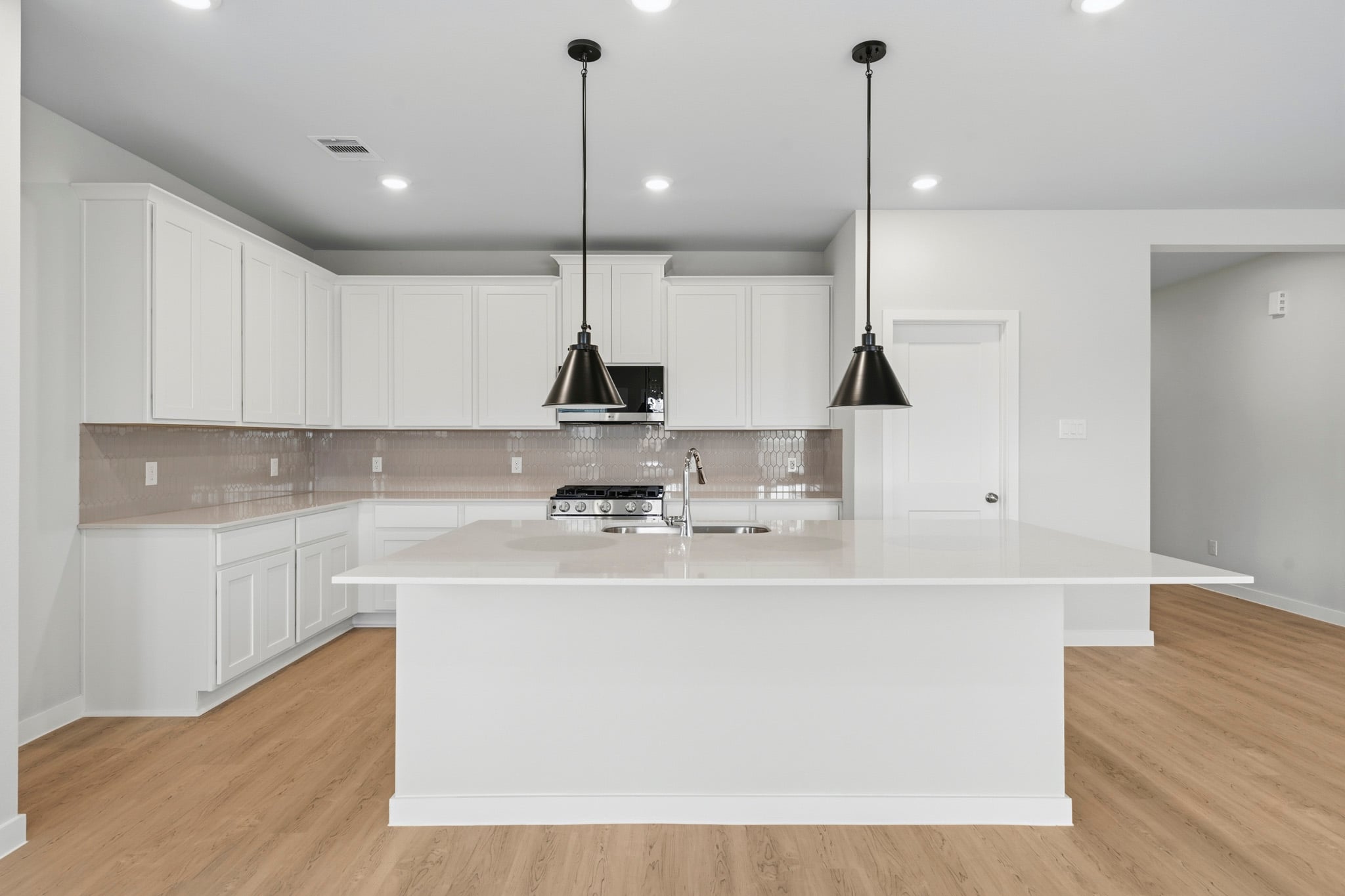A kitchen with white cabinets.