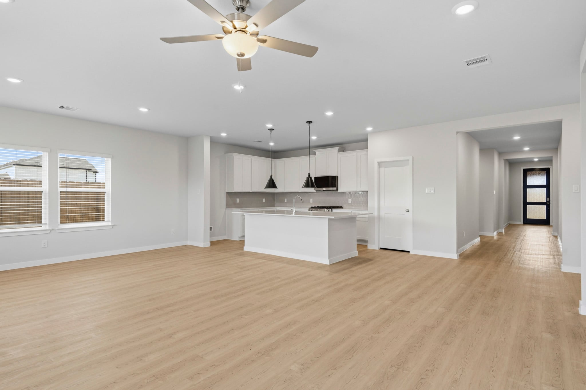 A large kitchen with a wood floor.
