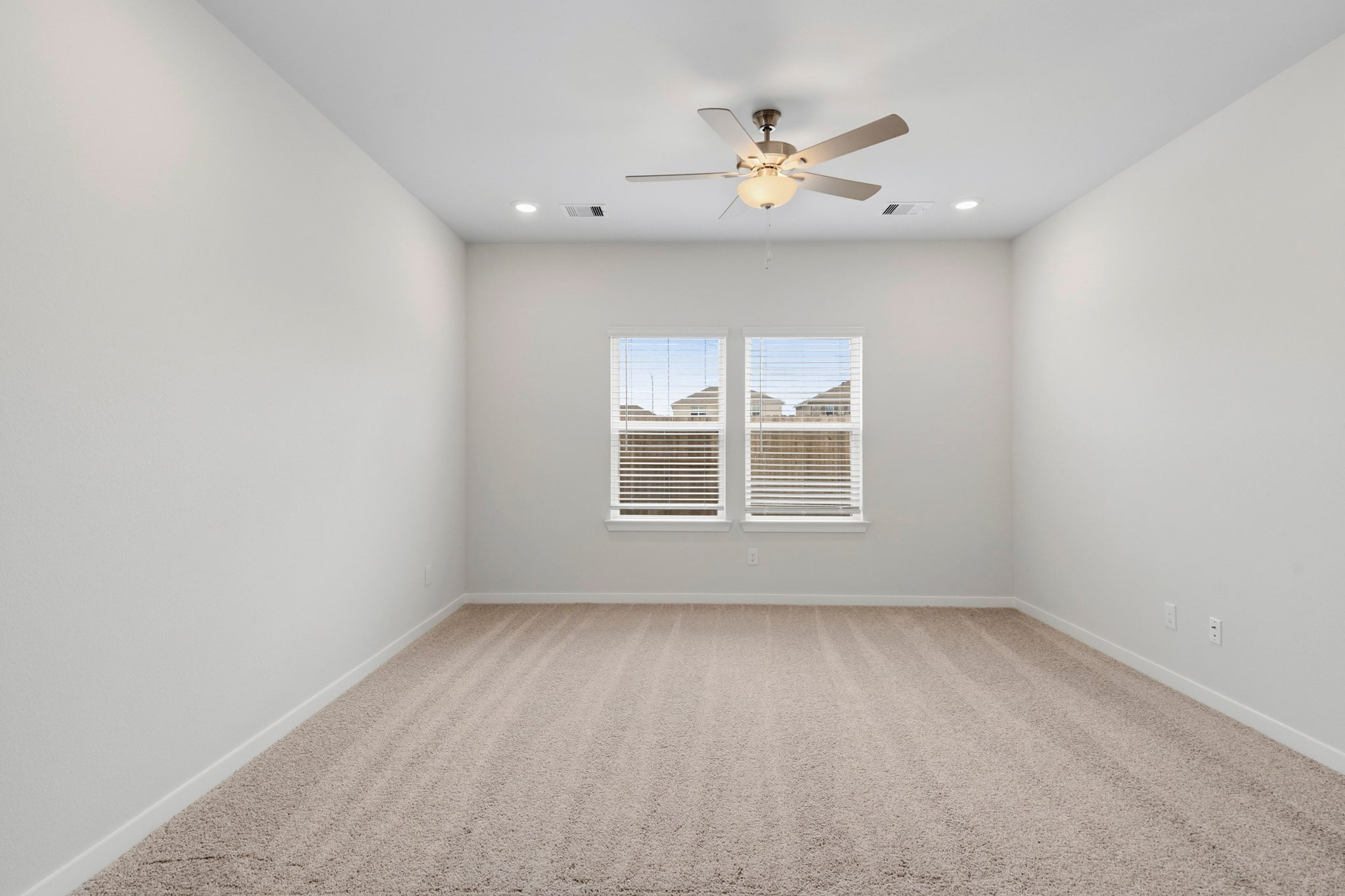 A room with a ceiling fan and a window.