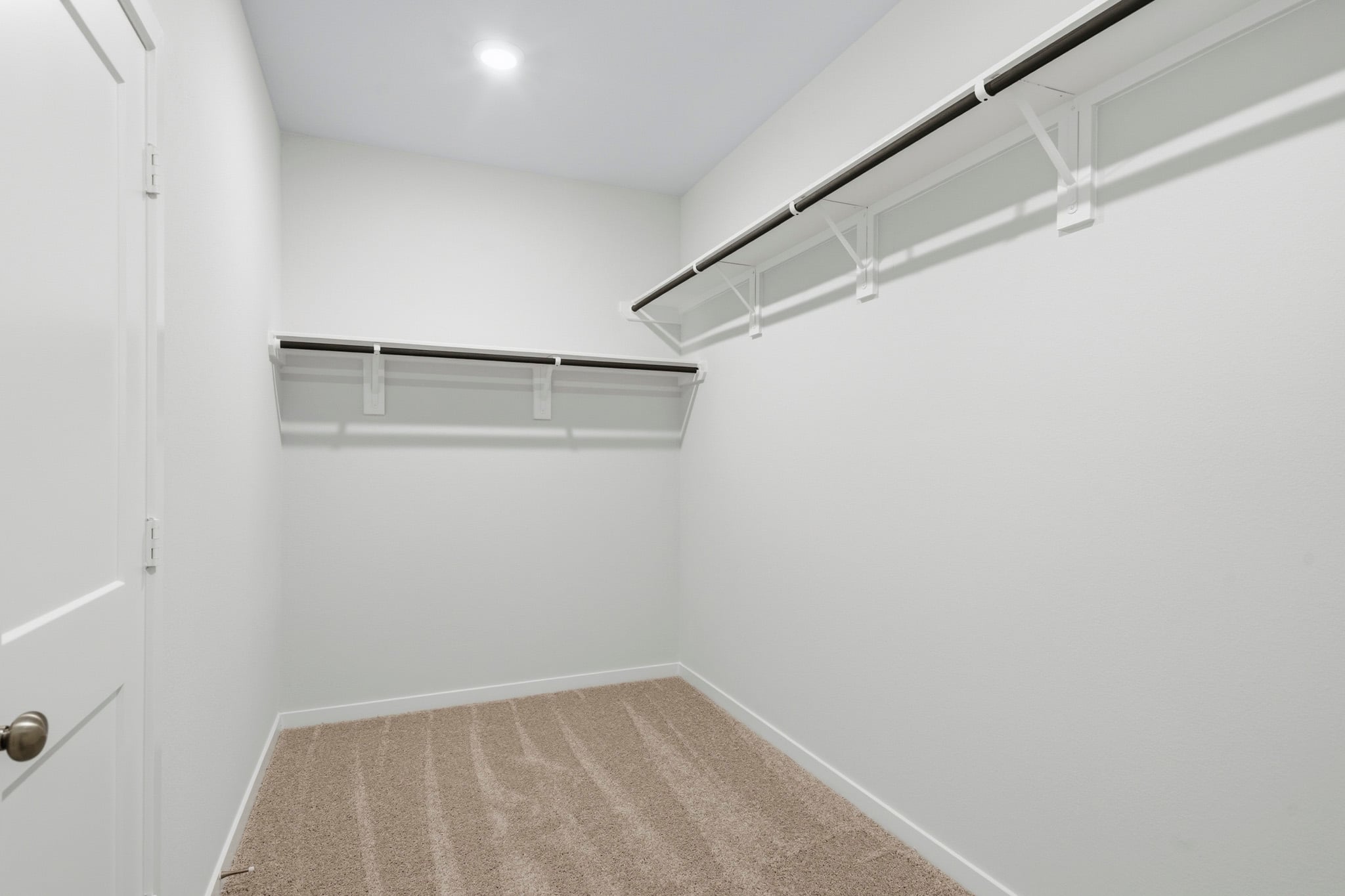 A white room with a carpet and a metal railing.