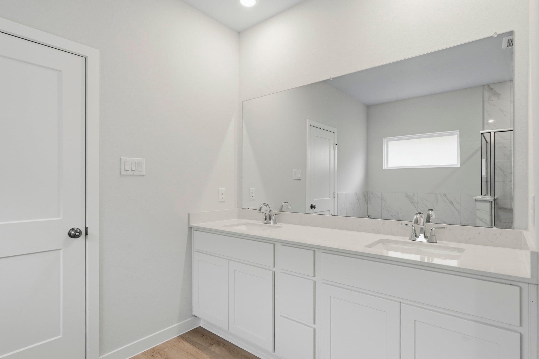 A bathroom with white cabinets.