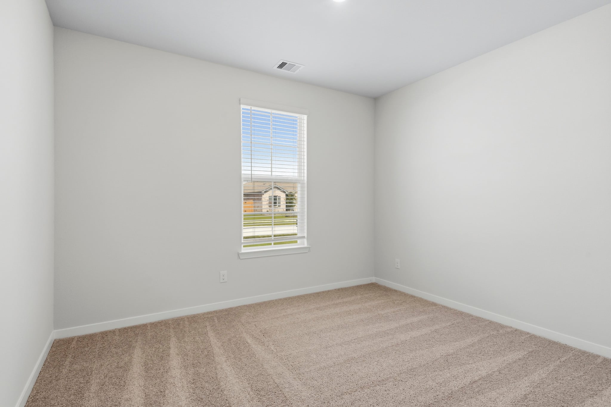 A room with a window and carpet.
