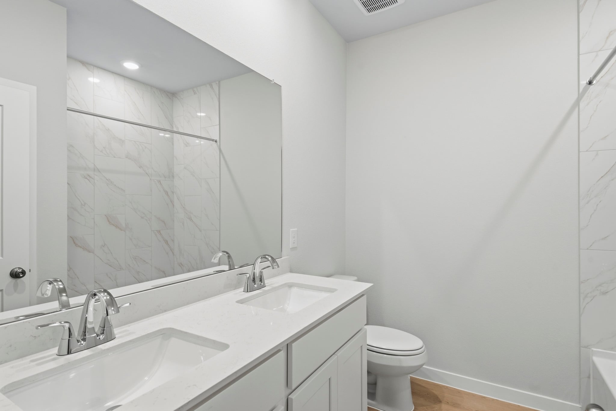 A bathroom with a large mirror.