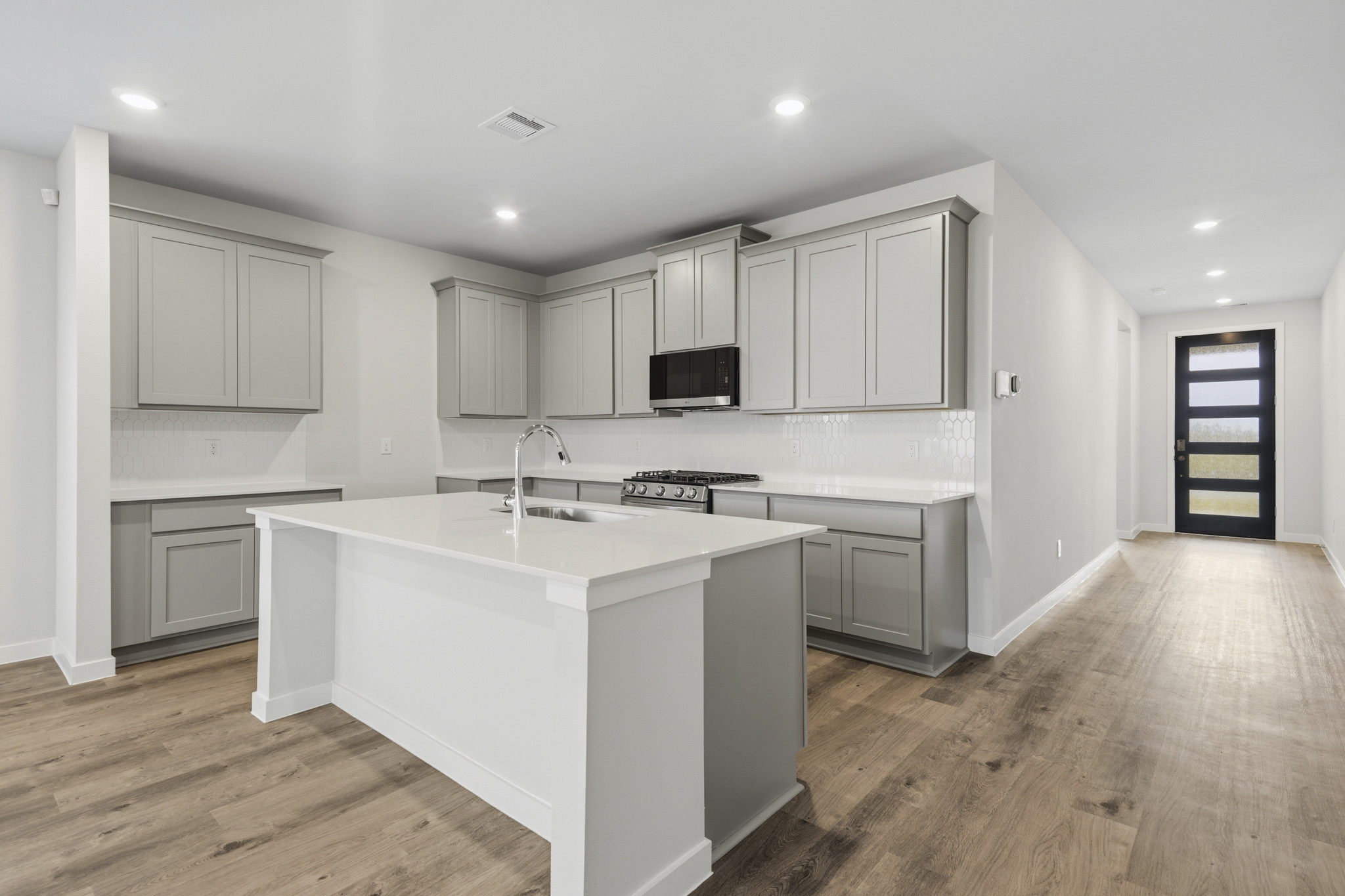 A kitchen with white cabinets.