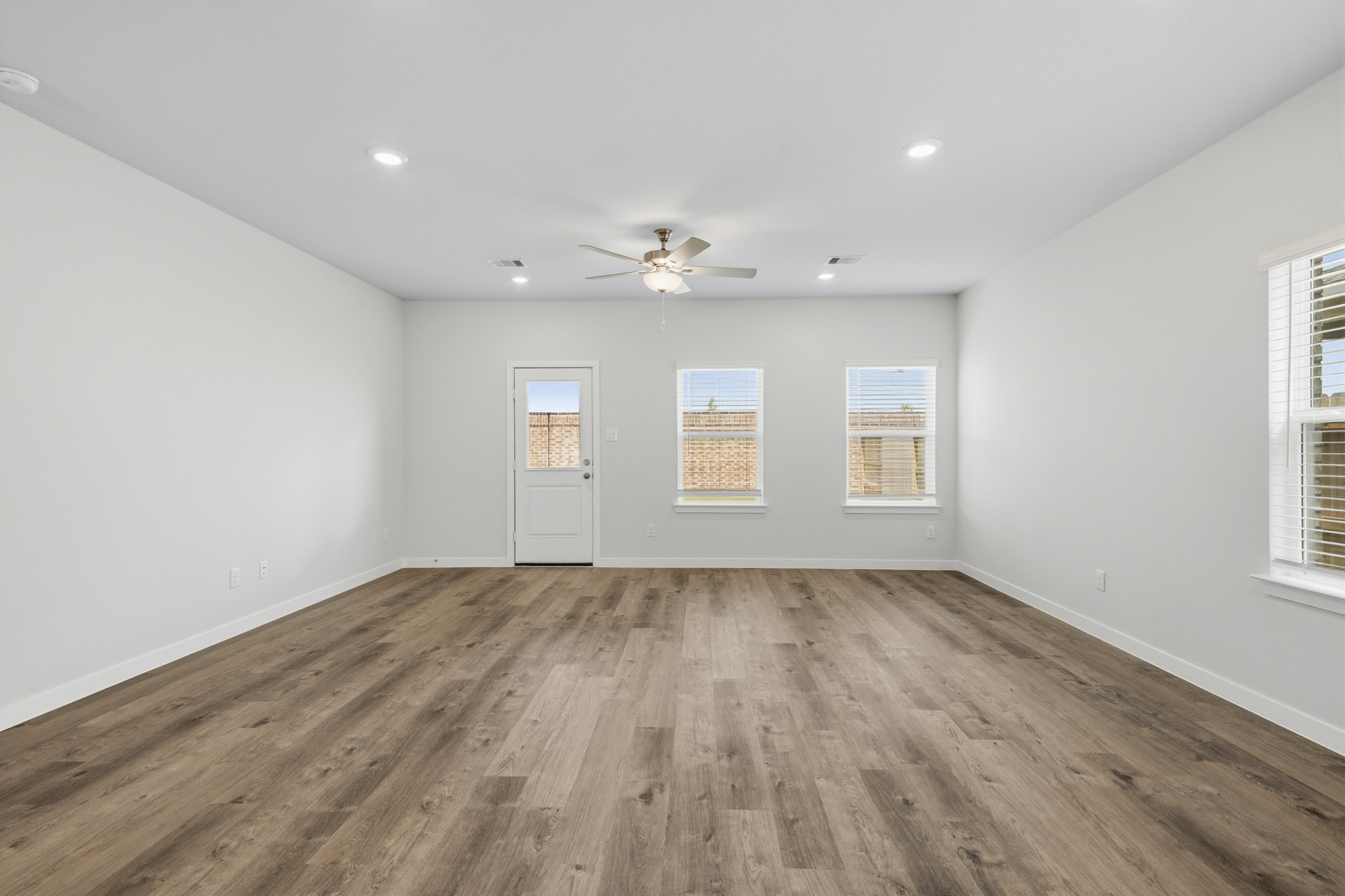 A room with a wood floor and a ceiling fan.