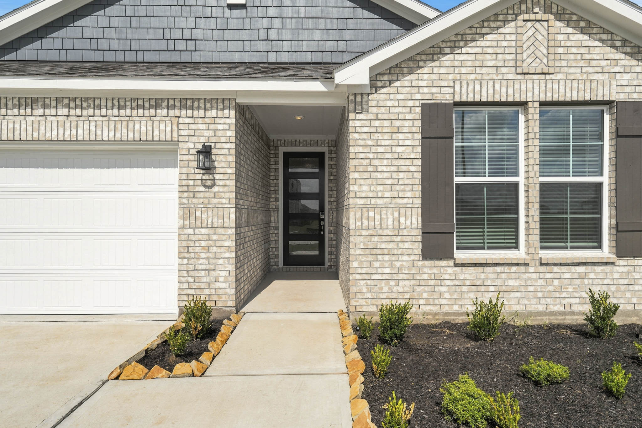 A house with a garage and a brick driveway.