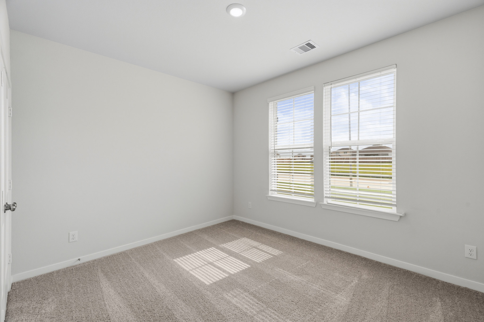 A room with a window and a rug.