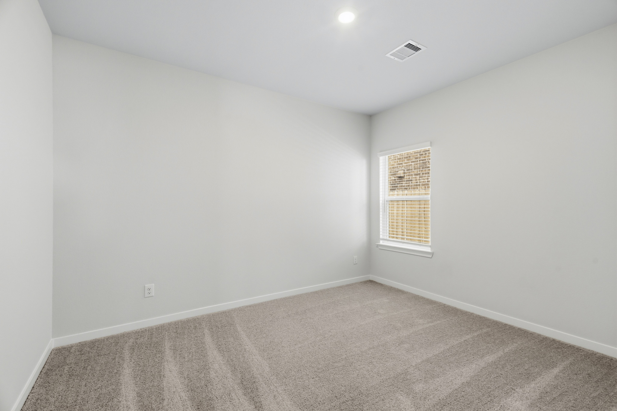A room with a carpet and a window.
