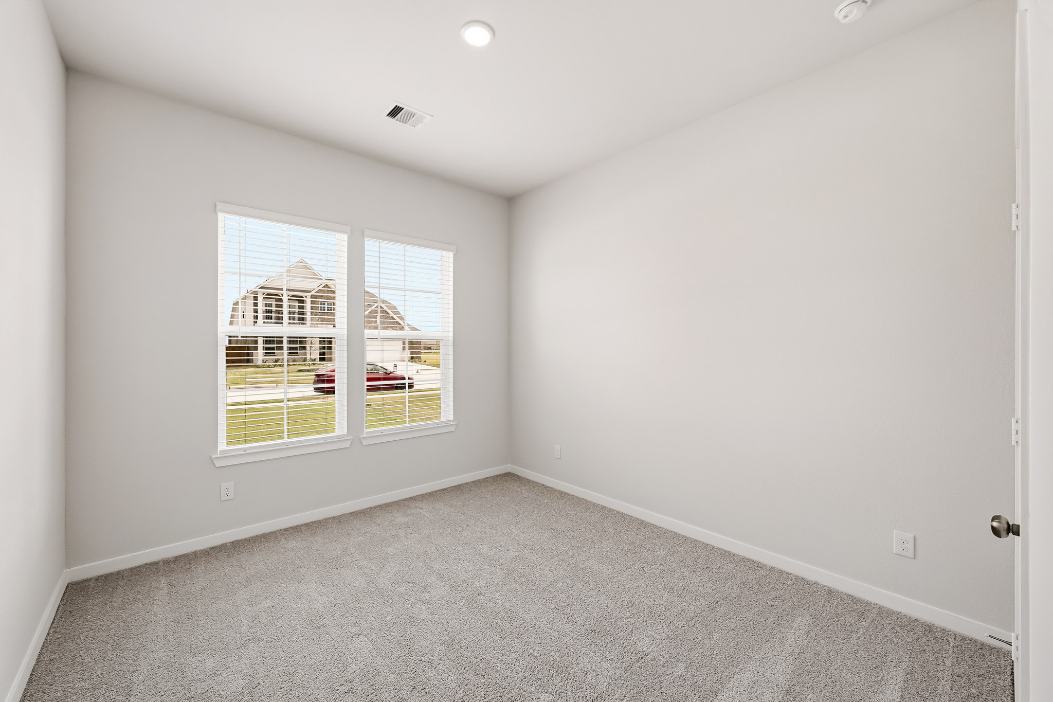 A room with a window and a carpet.