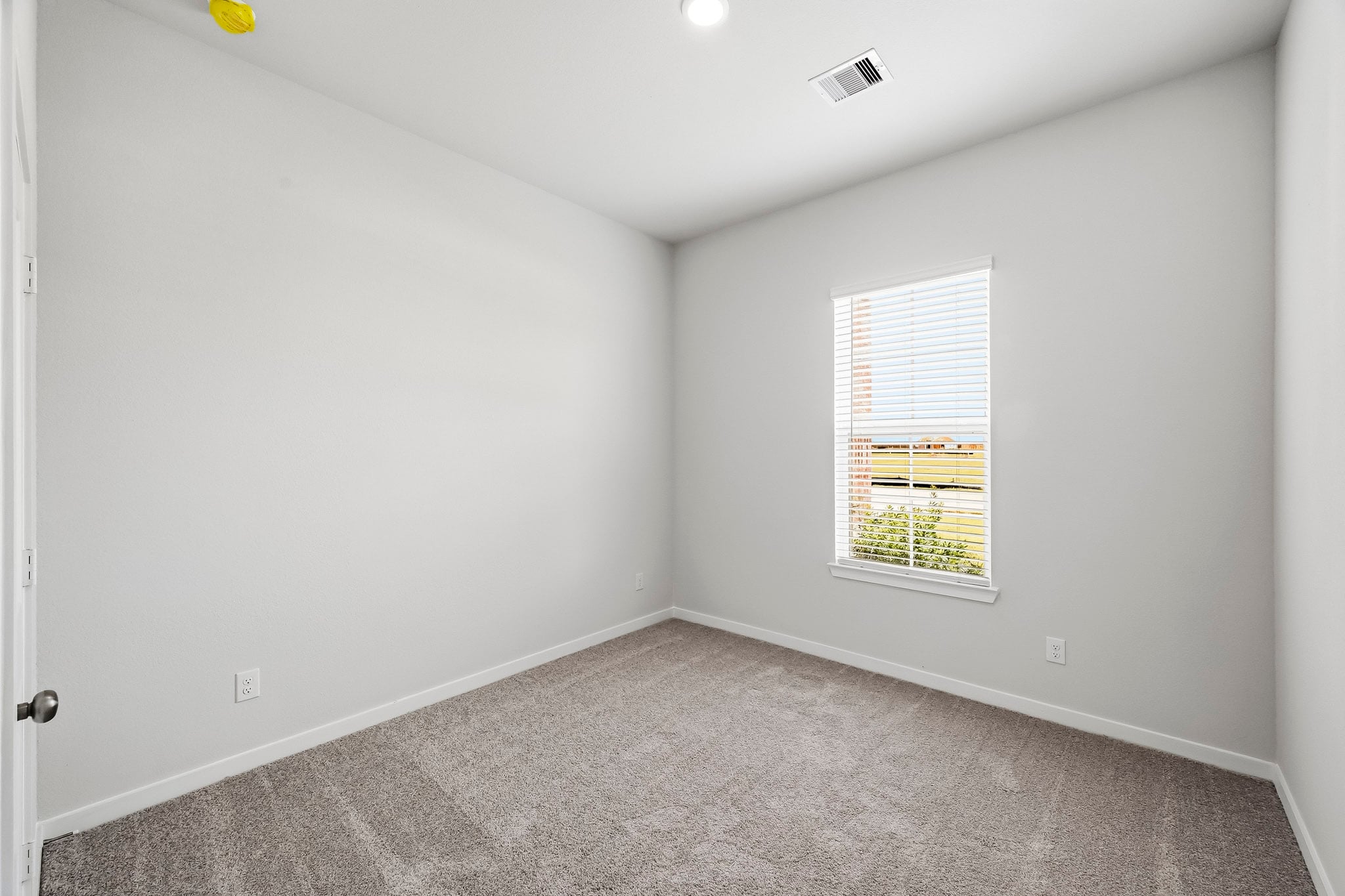 A room with a window and a carpet.