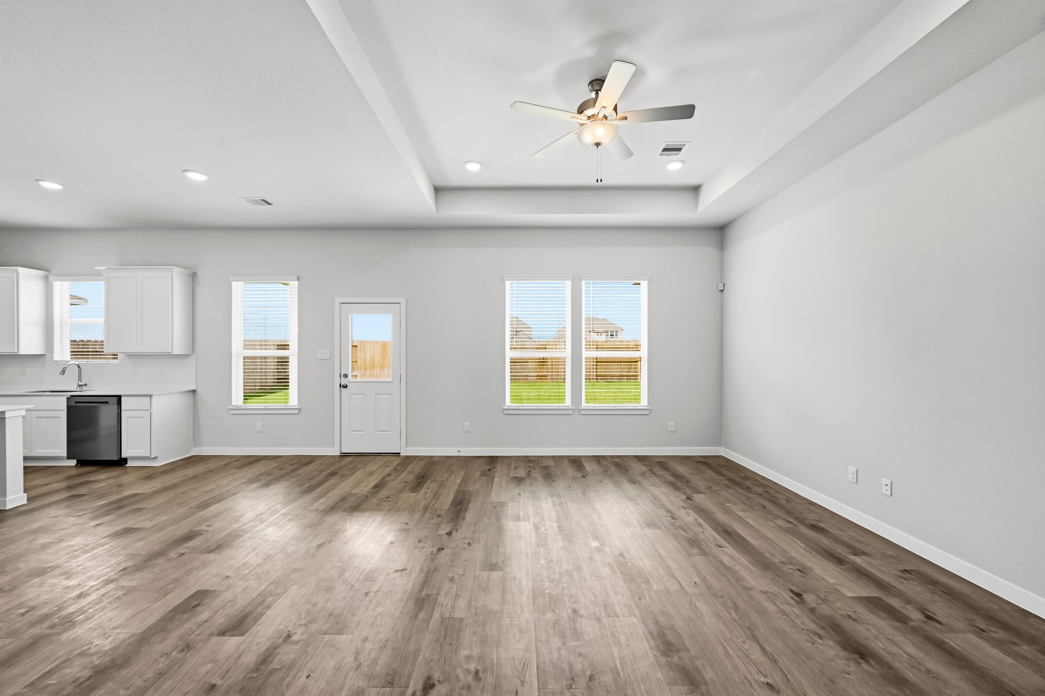 A room with a wood floor and a ceiling fan.