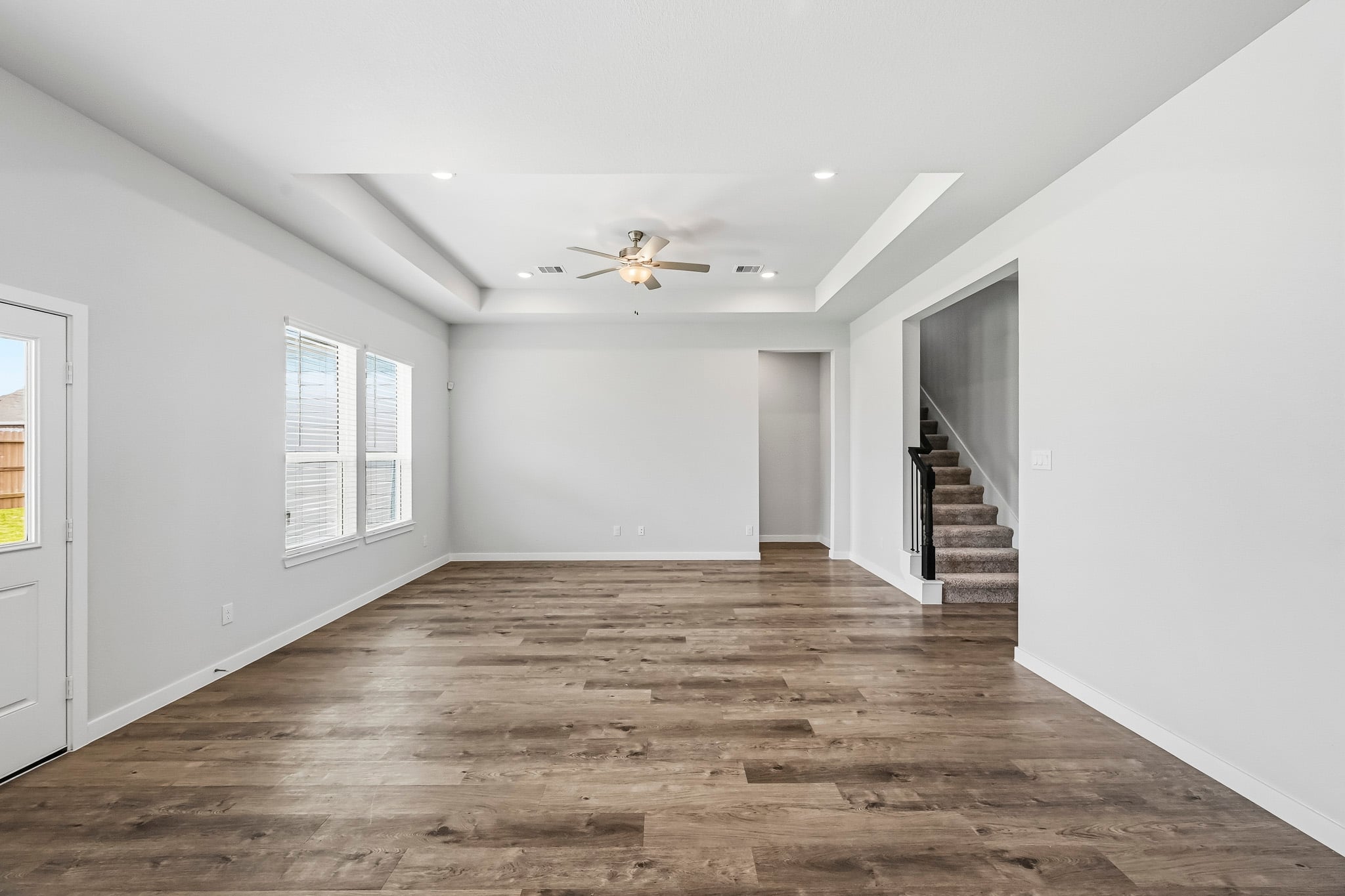 A room with a wood floor and a ceiling fan.