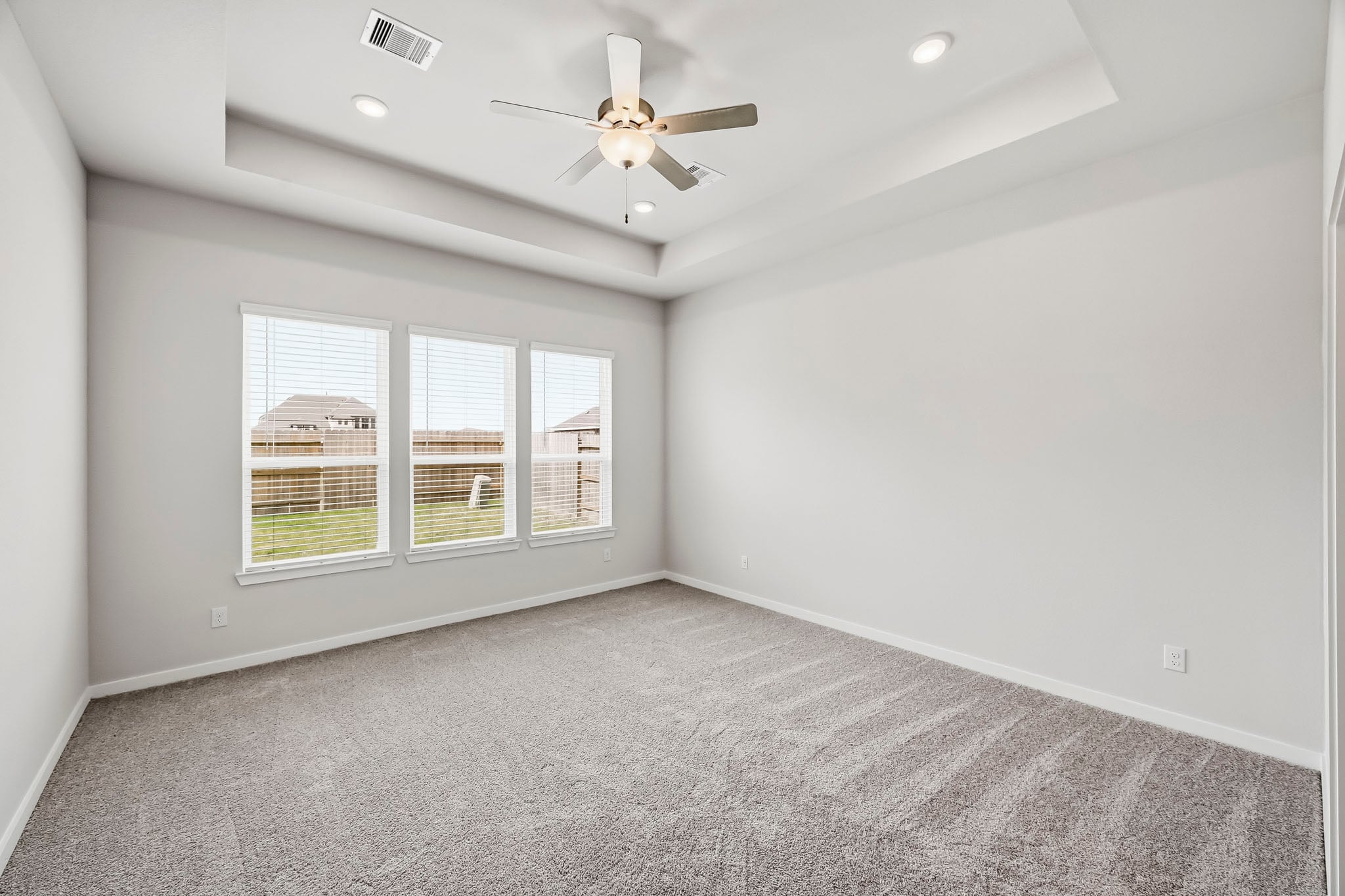 A room with a ceiling fan and a window.
