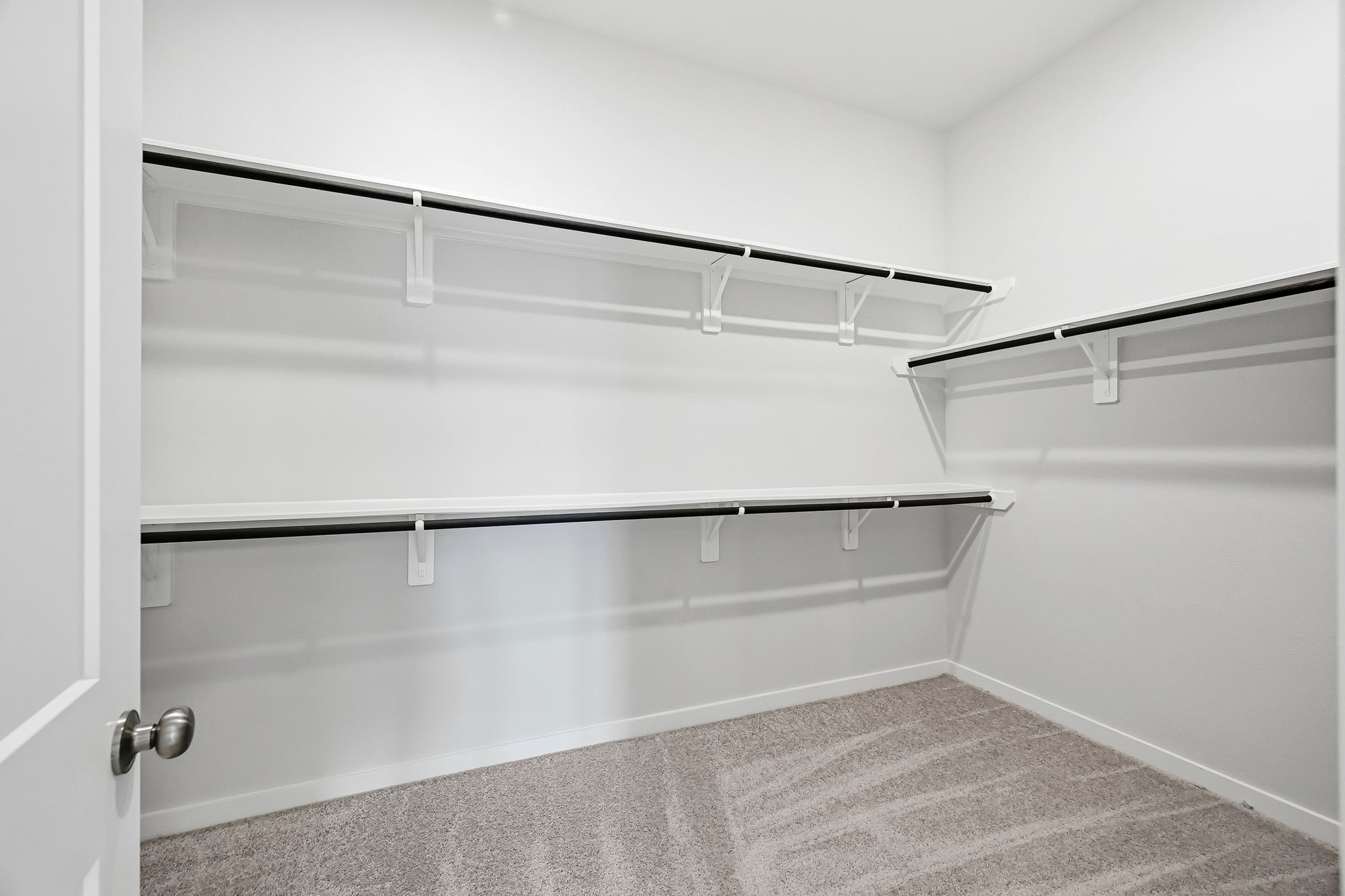 A white wall with a metal bar.
