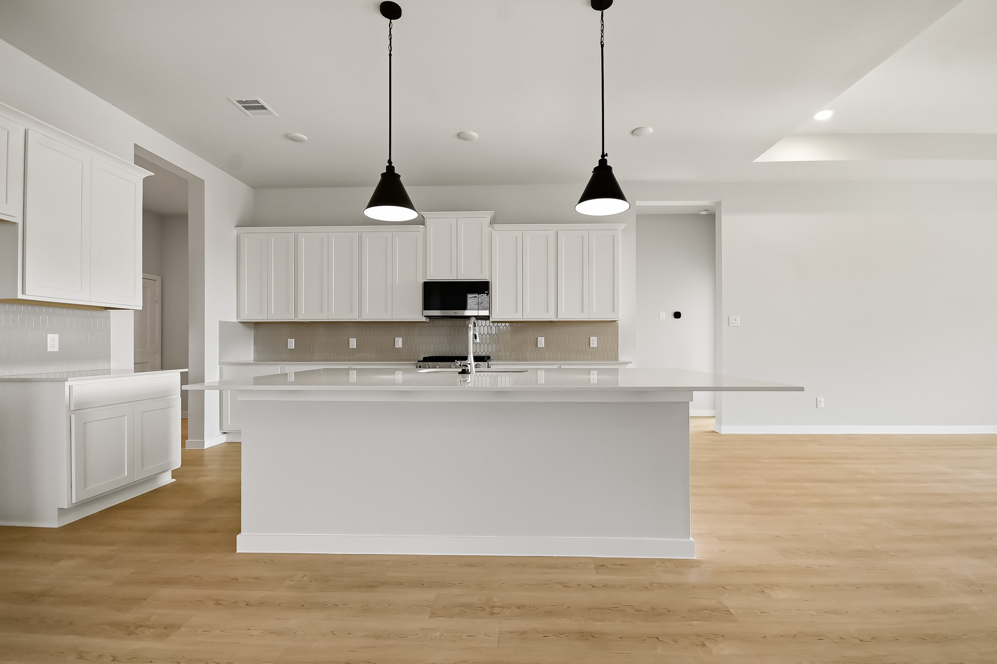 A kitchen with white cabinets.