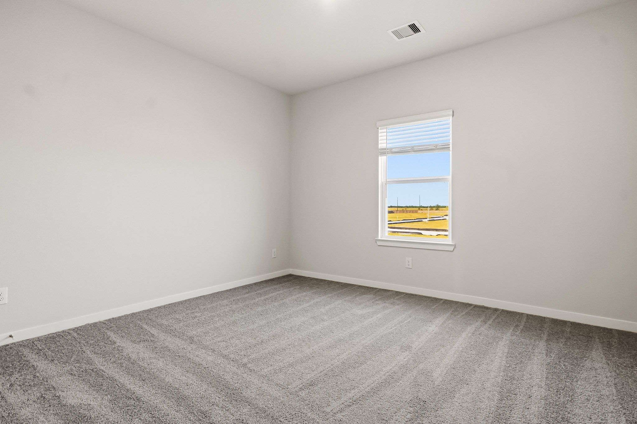 A room with a window and carpet.