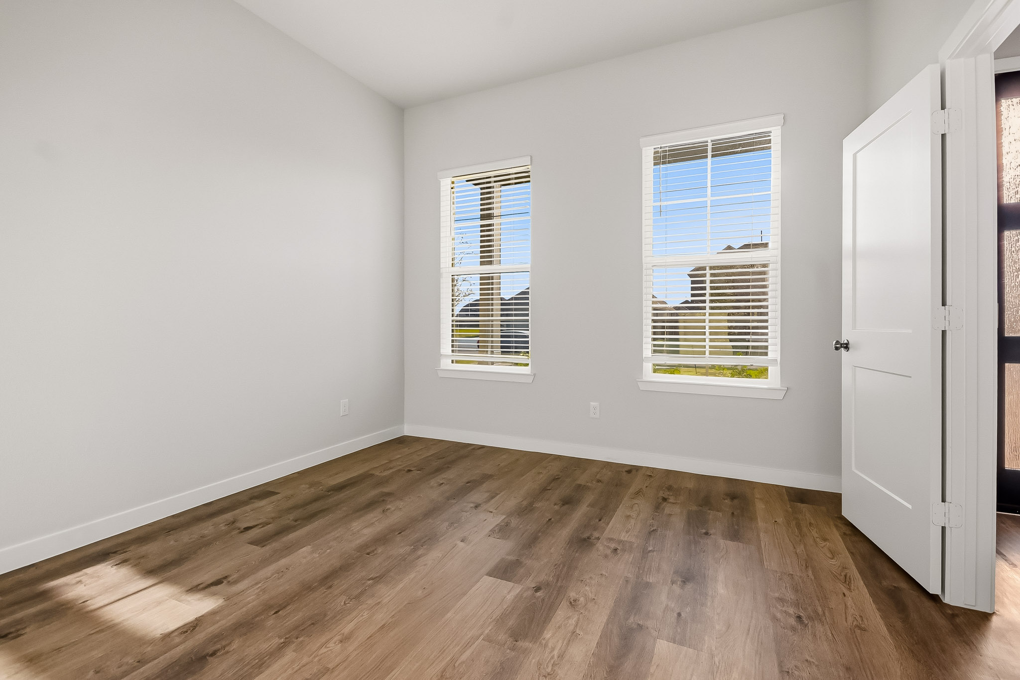 A room with a wood floor and white walls.