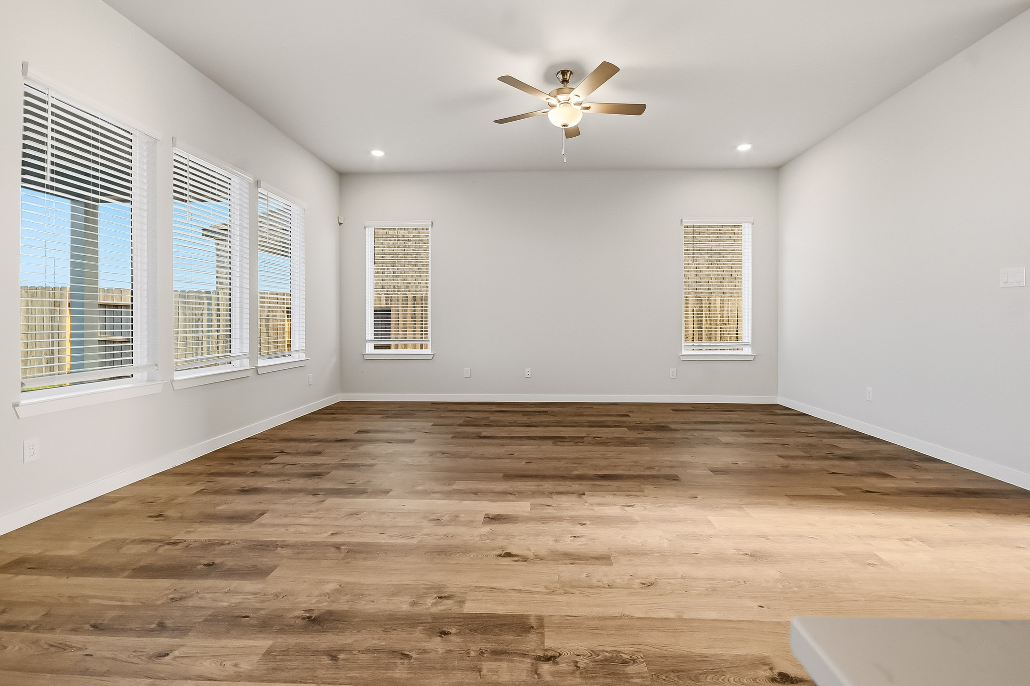 A room with a wood floor and a ceiling fan.