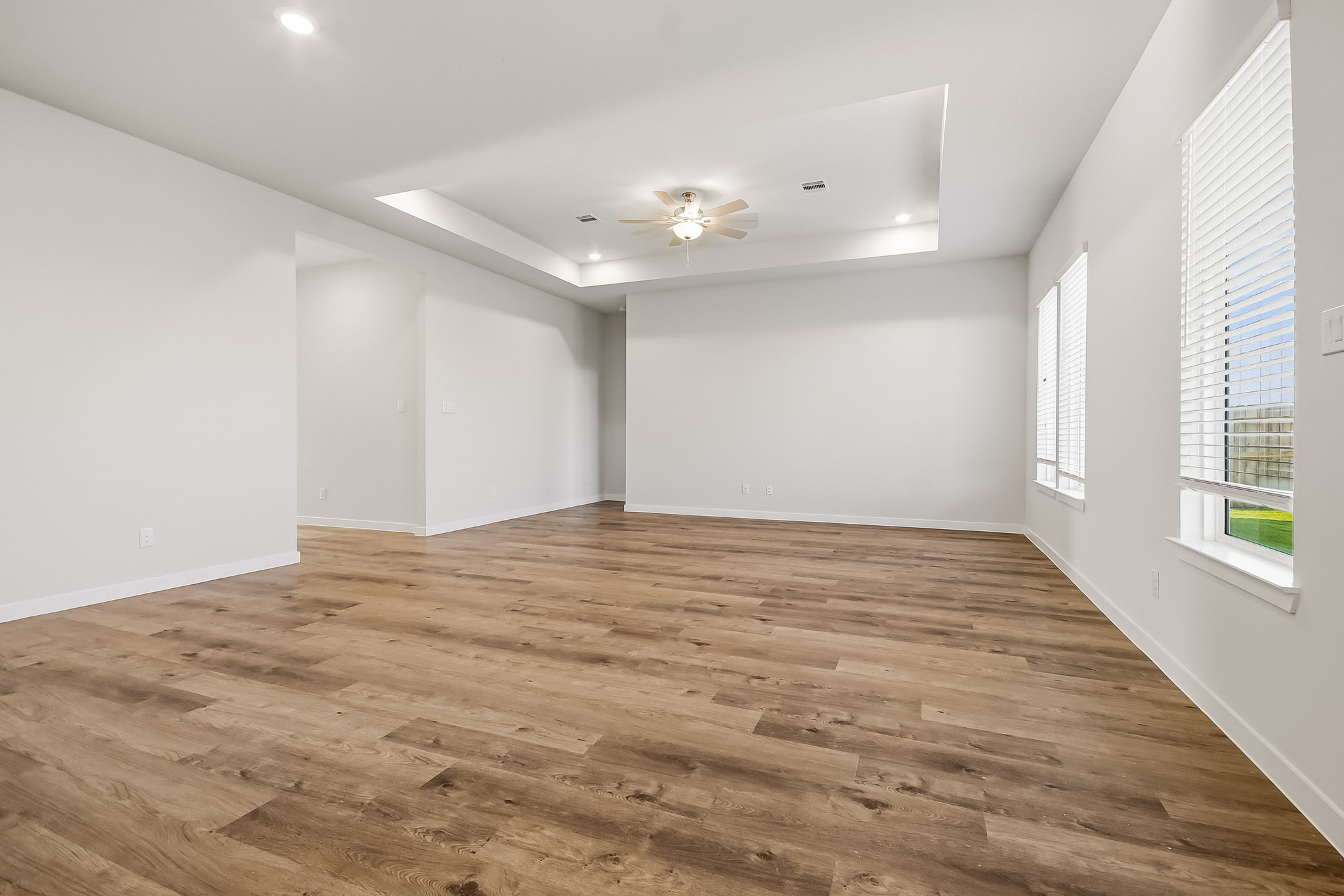 A room with a wood floor and a ceiling fan.