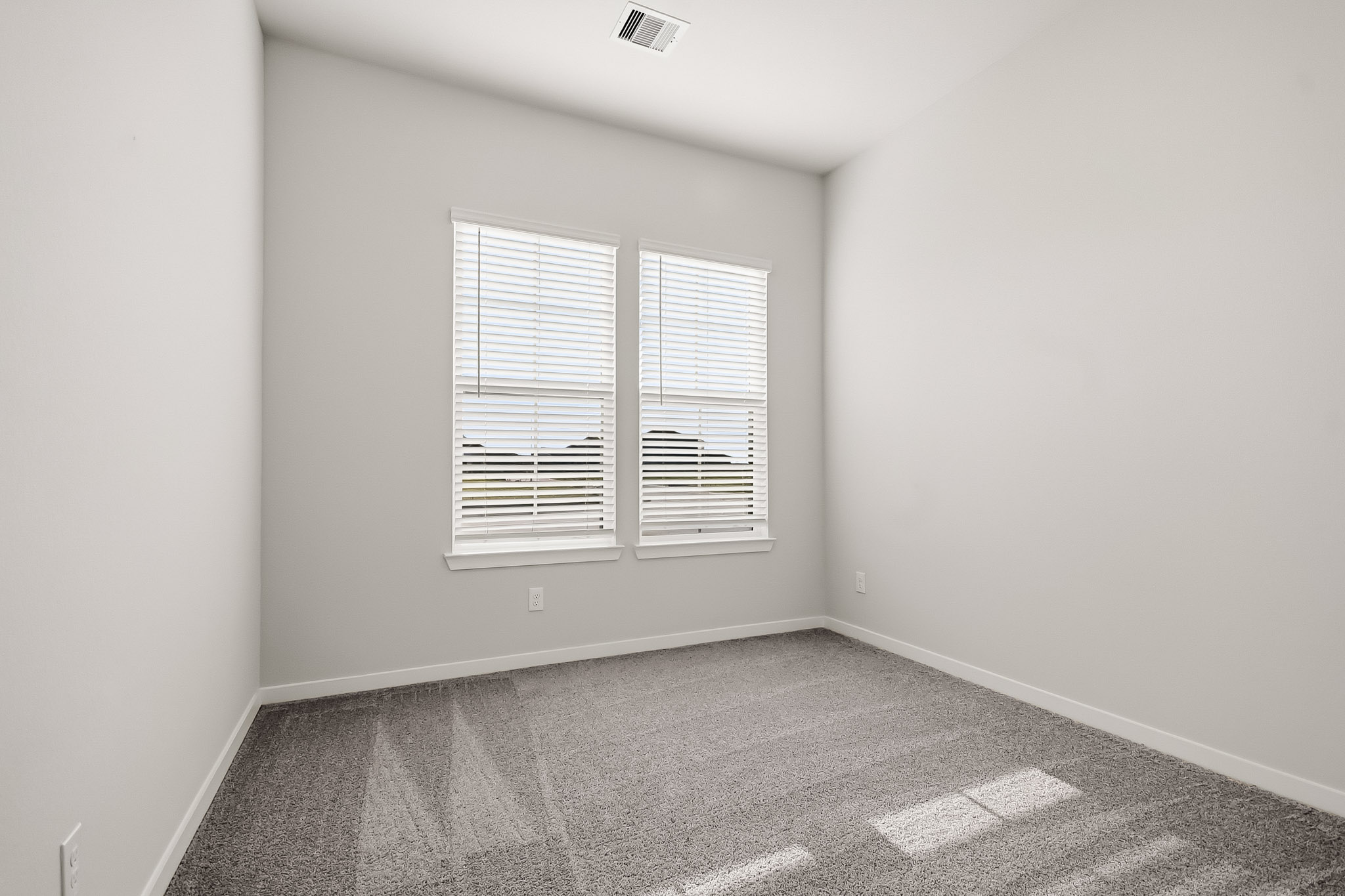 A room with a window and a rug.