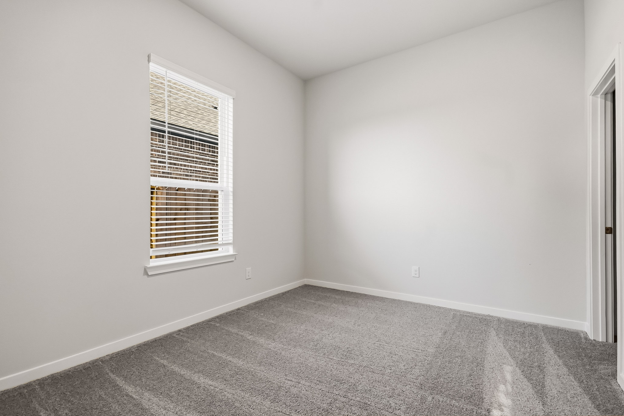 A room with a window and carpet.