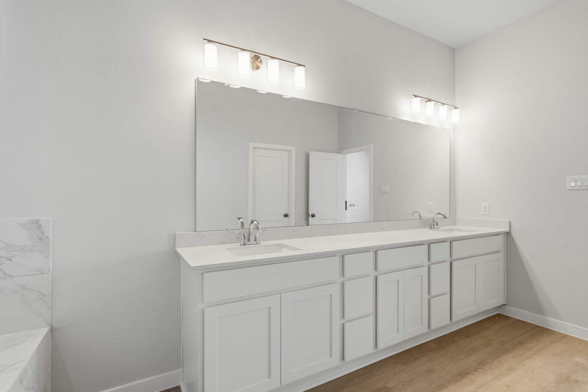 A bathroom with white cabinets.