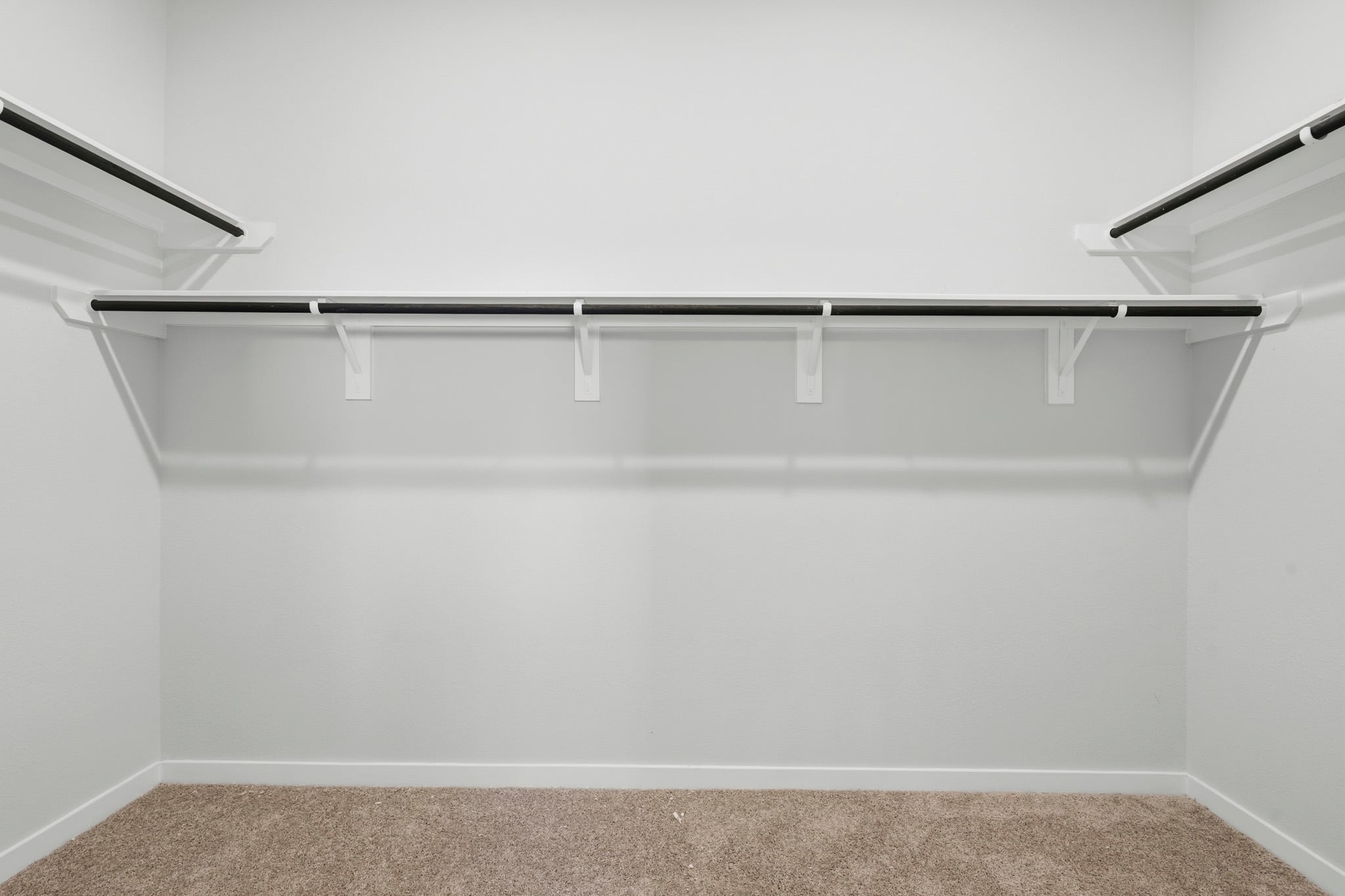A white wall with a metal bar.