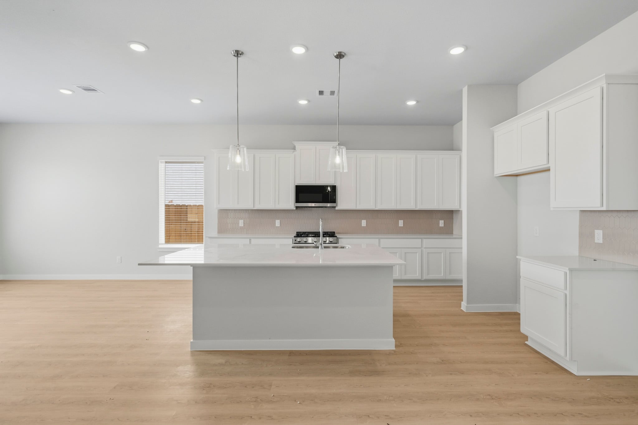 A kitchen with white cabinets.