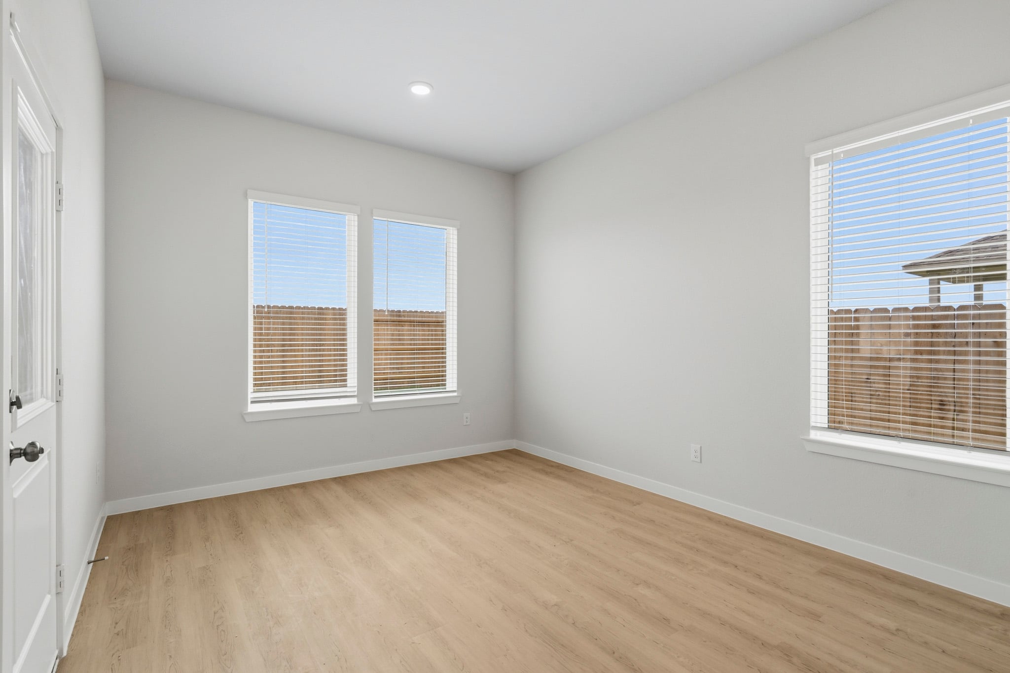A room with a wood floor and windows.
