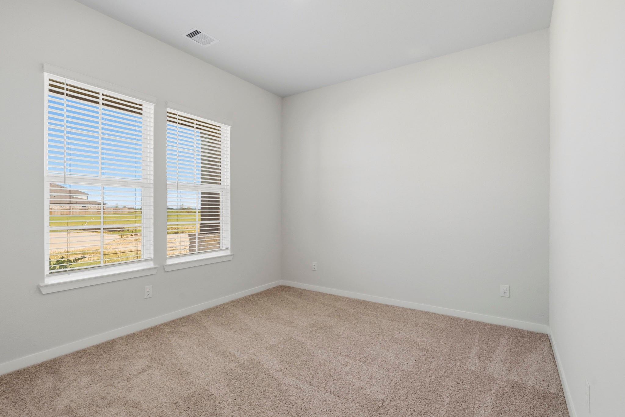 A room with a window and a carpet.