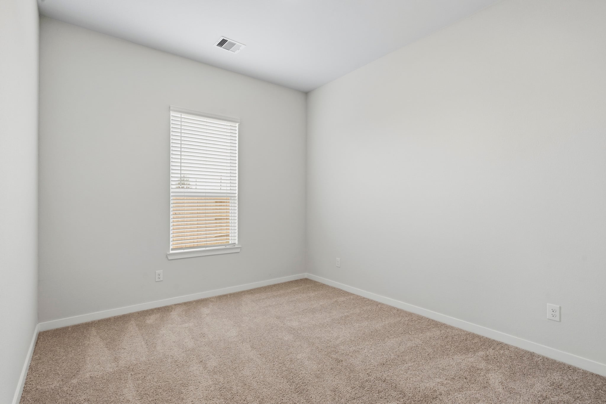 A room with a window and carpet.
