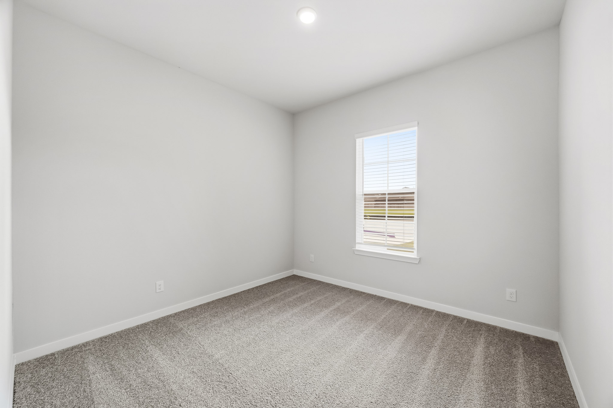 A room with a carpet and a window.
